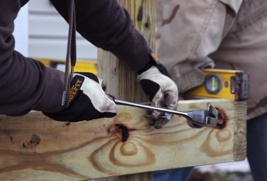 Skilled hands drive a nail into the frame of a wheelchair ramp being constructed by volunteers from Joint Base Andrews April 2.  In conjunction with Christmas in April * Prince George's County, volunteers helped make the Callahan residence, in Upper Marlboro, Md., wheelchair accessible.  David Callahan, 19,  was paralyzed in an automobile accident Jan. 23 on the Capitol Beltway.  The accident also claimed the life of his 21 year old brother, David.  The boys' mother works for the Judge Advocate General at the Washington Navy Yard on Joint Base Andrews. (U.S. Air Force Photo by Senior Airman Torey Griffith.)(Released)