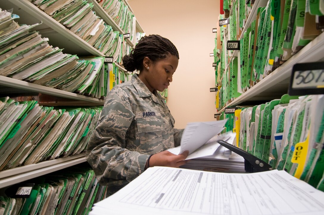 Airman Kiana Parker, 779th Medical Support Squadron health services management technician, organizes patient records in the outpatient records section of Malcolm Grow Medical Center for an upcoming health services inspection April 6. Airman Parker, a reservist from Pope Air Force Base, NC., is assigned to the 779 MDSS for 80-day seasonal training. (Photo by Bobby Jones)