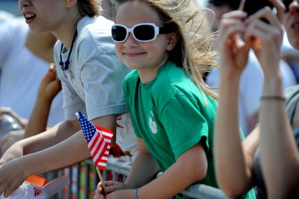 Eight year old Louise Martin waves an American flag as she watches the GEICO skytypers perform during Family Day April 8 at Joint Base Charleston, S.C. The GEICO skytypers performed low-level precision formation flying for nearly 80,000 people at the Charleston Air Expo 2011.  (U.S. Air Force photo/ Staff Sgt. Nicole Mickle)  