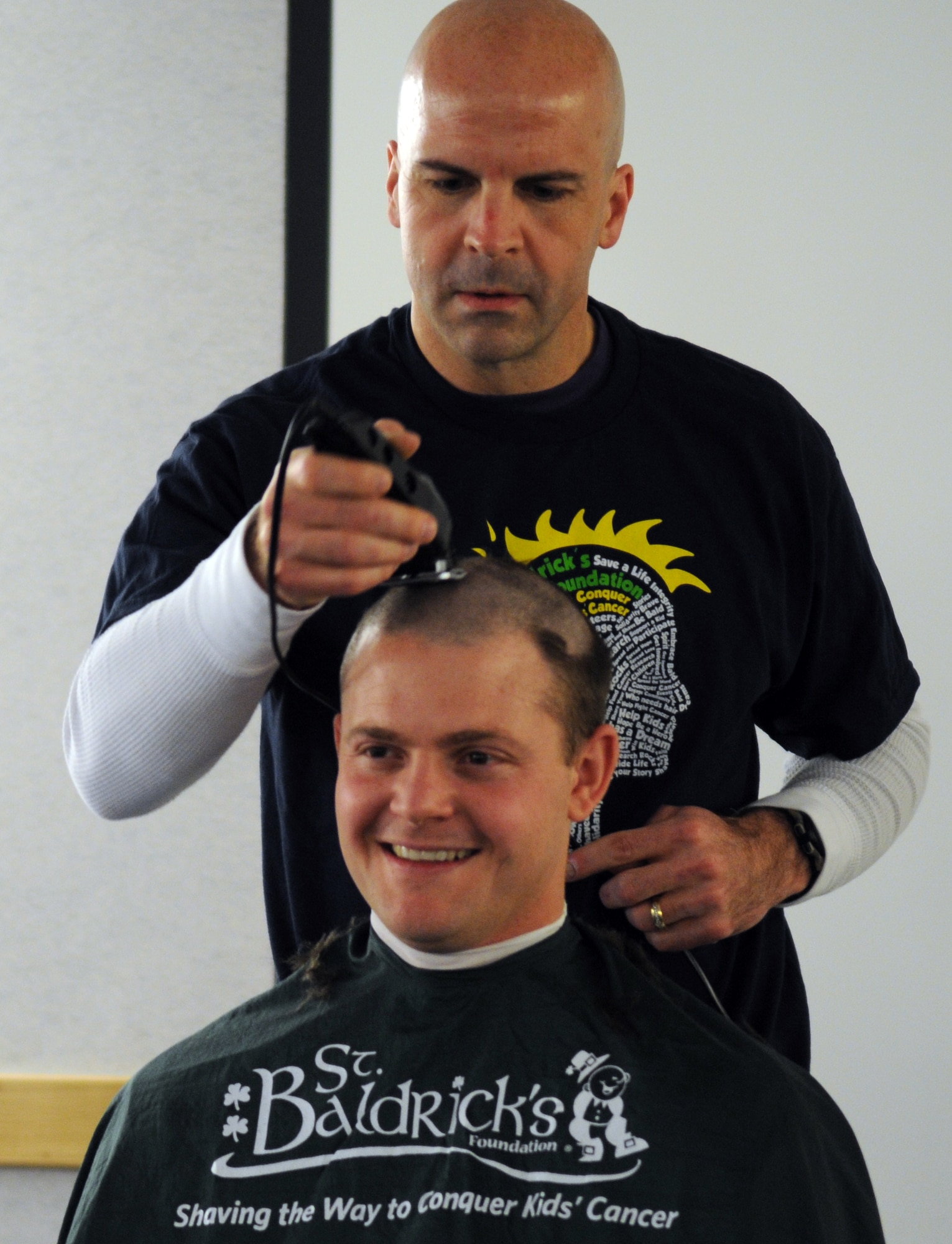 RAF MILDENHALL, England -- Col. Chad Manske, 100th Air Refueling Wing commander, shaves off Capt. Clinton Albaugh’s, 100th ARW plans and programs, hair during a St. Baldrick’s Foundation event at the 100th Operations Group auditorium April 7, 2011. According to the St. Baldrick’s Foundation website, the foundation is a volunteer-driven charity committed to funding research to find cures for childhood cancers. Volunteers for the organization raise funds by taking pledges to shave off their hair. Captain Albaugh was one of the top fundraisers and the Century Tanker Committee raised more than $7,500 for the foundation. (U.S. Air Force photo/Airman 1st Class Rachel Waller)
