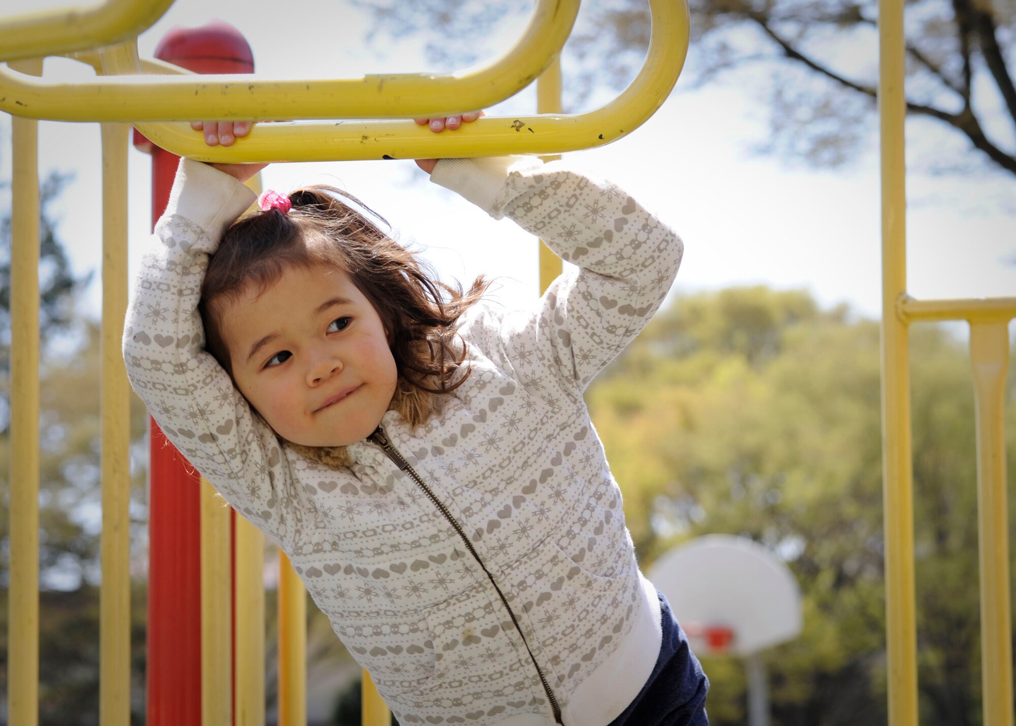 YOKOTA AIR BASE, Japan -- Emily Treiber, 4, plays on a set of monkey bars here April 12, 2011. As warm weather arrives, families are encouraged to enjoy a variety of outdoor recreational activities. (U.S. Air Force photo/Airman 1st Class Andrea Salazar)