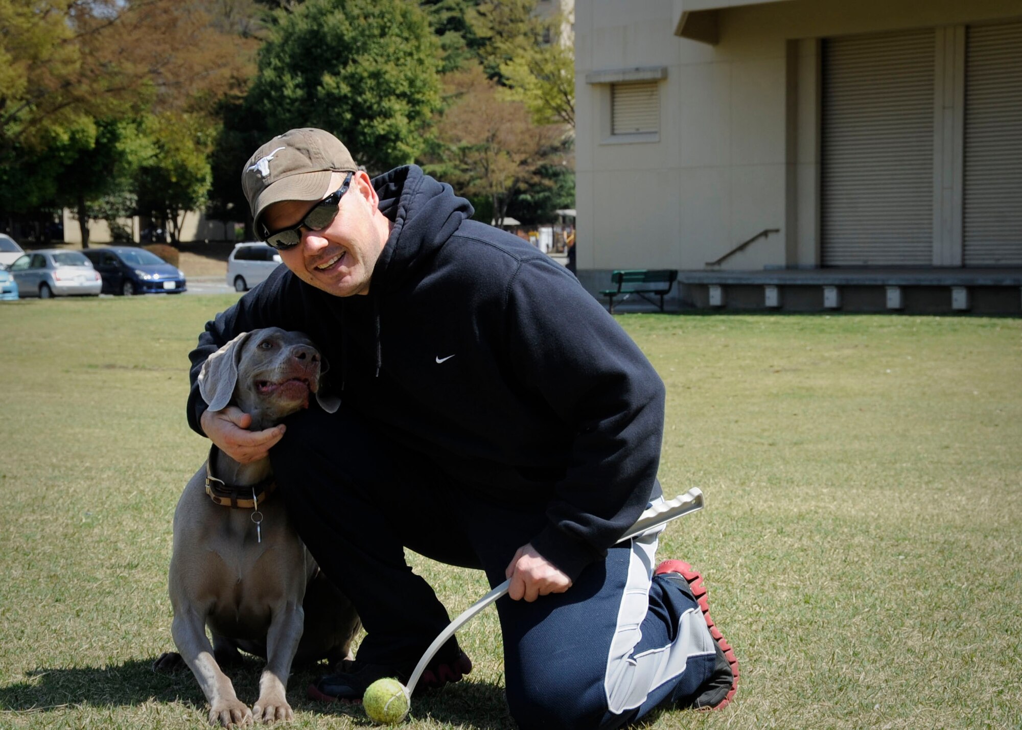 YOKOTA AIR BASE, Japan -- Master Sgt. Gary Jones, 730th Air Mobility Squadron professional superintendent, pets his dog Maggie outside the Sakura Shell April 12, 2011. With spring-time here, many people head outdoors for activities including walks, outdoor grilling and sports, among other activities. (U.S. Air Force photo/Airman 1st Class Andrea Salazar)
