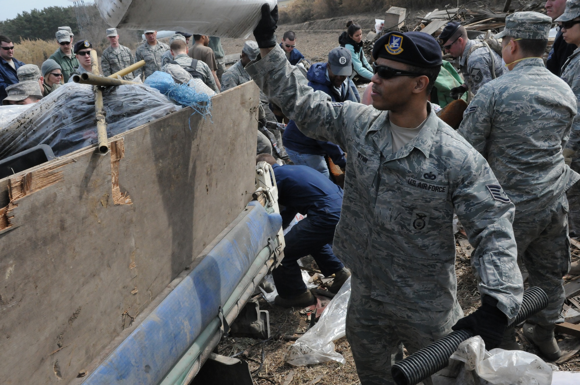 HACHINOHE, Japan --  Staff Sgt. Curtis Wynn, 35th Security Forces Squadron, loads debris from a Hachinohe strawberry field into the back of a flatbed truck April 7. Sergeant Curtis, along with a few dozen Misawa residents, made the trip to the northeastern Pacific coastal city to help restore this agricultural area and help clear debris from Aomori prefecture. (U.S. Air Force photo/Staff Sgt. Erica Picariello)