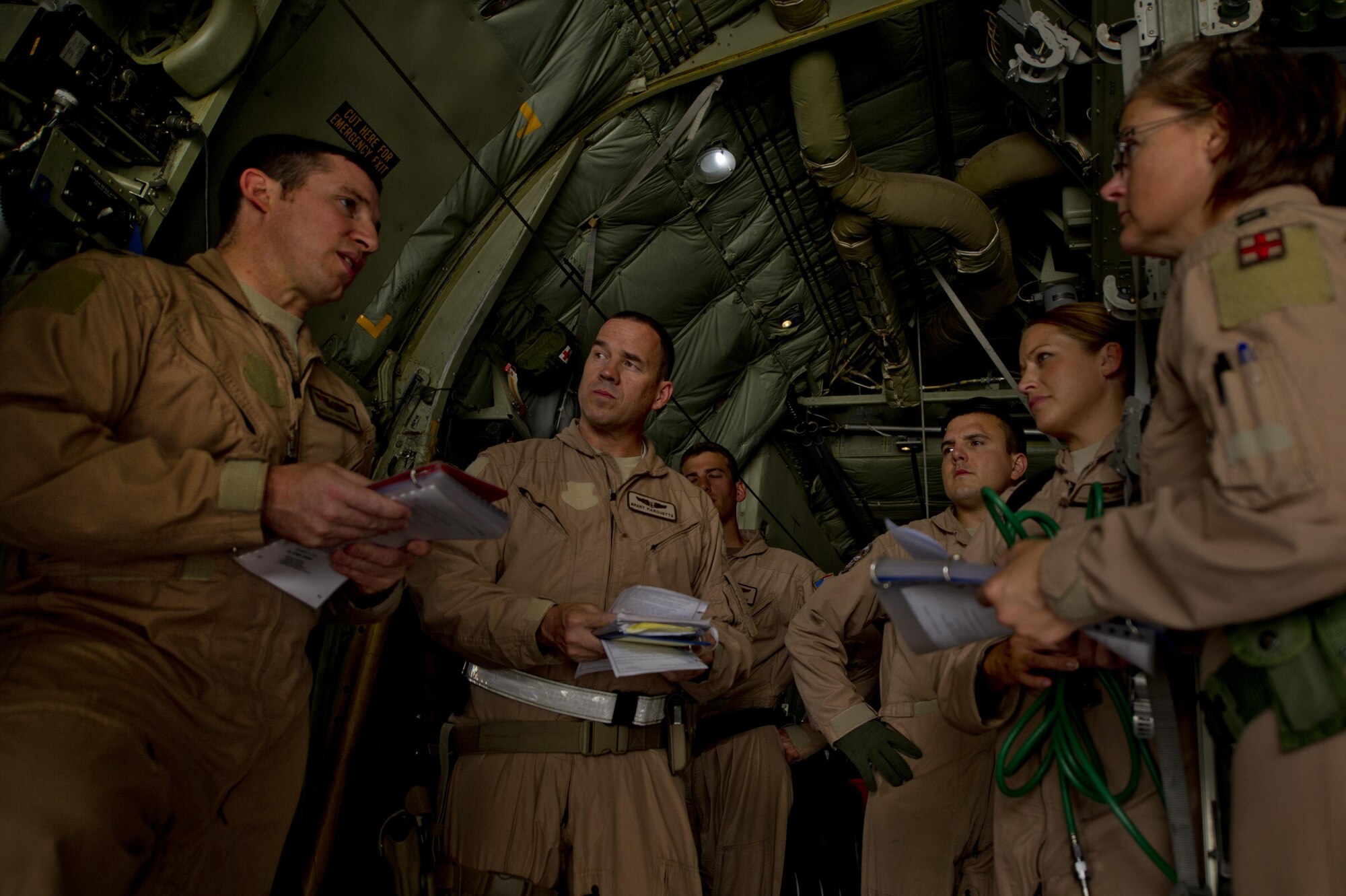 Members of the 746th Expeditionary Airlift Squadron and 379th Expeditionary Aeromedical Evacuation Squadron gather together for a crew brief prior to an aeromedical evacuation mission at an undisclosed location in Southwest Asia. (U.S. Air Force photo/Master Sgt. Adrian Cadiz)