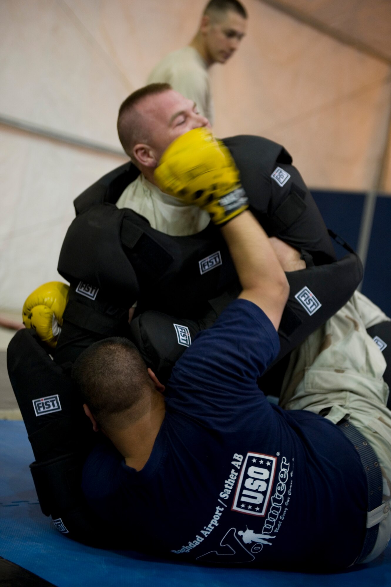 SATHER AIR BASE, Iraq -- Staff Sgt. Branden Gallacher, top, 447th Expeditionary Security Forces Squadron, grapples with an Iraqi airman April 8.  Members of the 447th ESFS trained Iraqi security forces airmen ensuring weapons qualification and teaching defensive tactics, vehicle searches and other force protection measures. Sergeant Gallacher is deployed from the 151st Security Forces Squadron, Utah Air National Guard, and is a native of Cortez, Colo.(U.S. Air Force photo by Staff Sgt. Levi Riendeau)