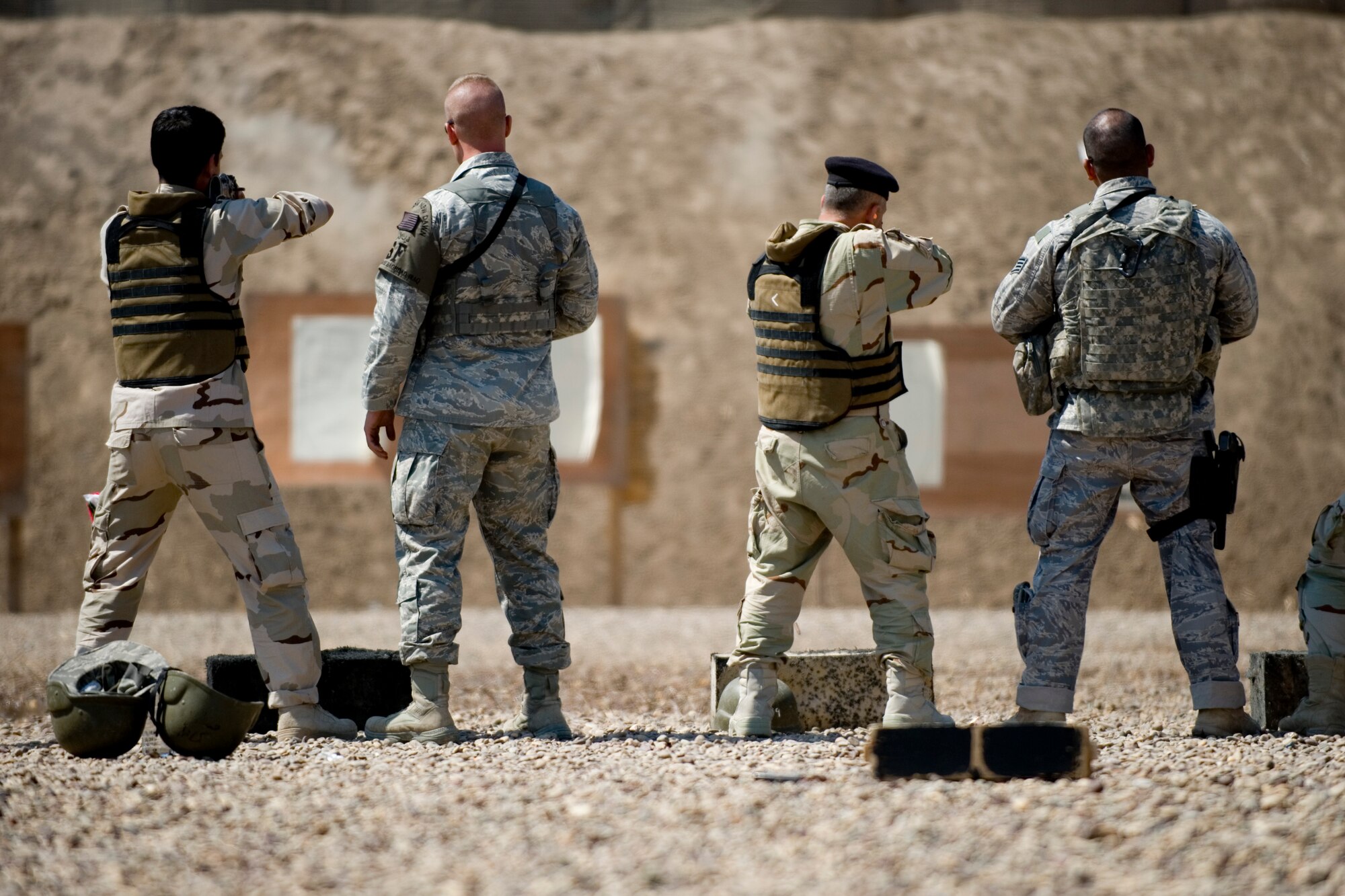 BAGHDAD -- Airmen from the 447th Expeditionary Security Forces Squadron observe Iraqi airmen during firing drills March 29. Members of the 447th ESFS trained Iraqi security forces airmen ensuring weapons qualification and teaching defensive tactics, vehicle searches and other force protection measures. (U.S. Air Force photo by Staff Sgt. Levi Riendeau)