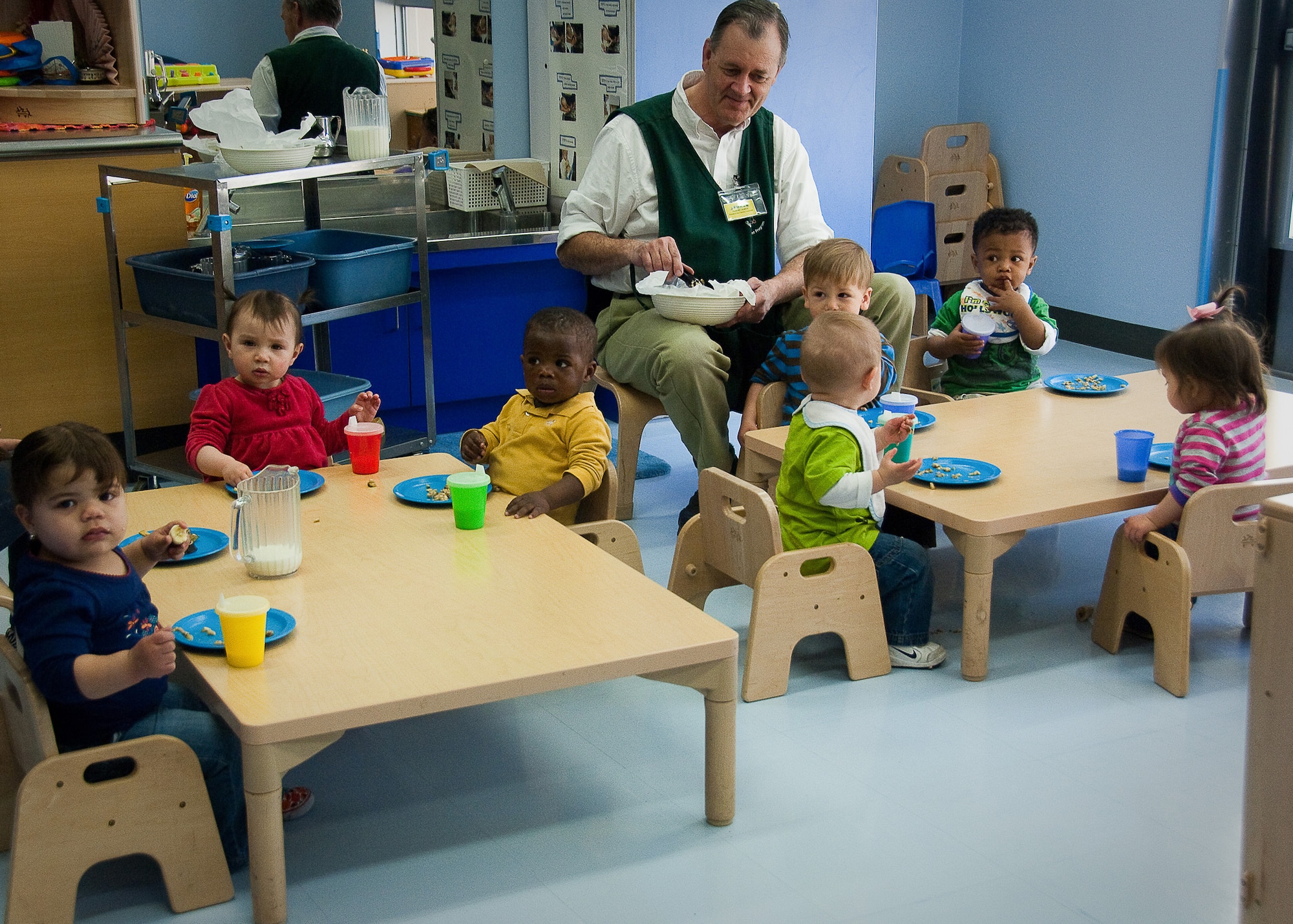 YOKOTA AIR BASE, Japan -- Bob Huber, pre-toddler room lead at the Yume Child Development Center, feeds an afternoon snack to the younger children here April 12. Caregivers at the Yume and Kibo CDCs work together to continue normal routines with the children by carrying on everyday activities. (U.S. Air Force photo/Airman 1st Class Lynsie Nichols)