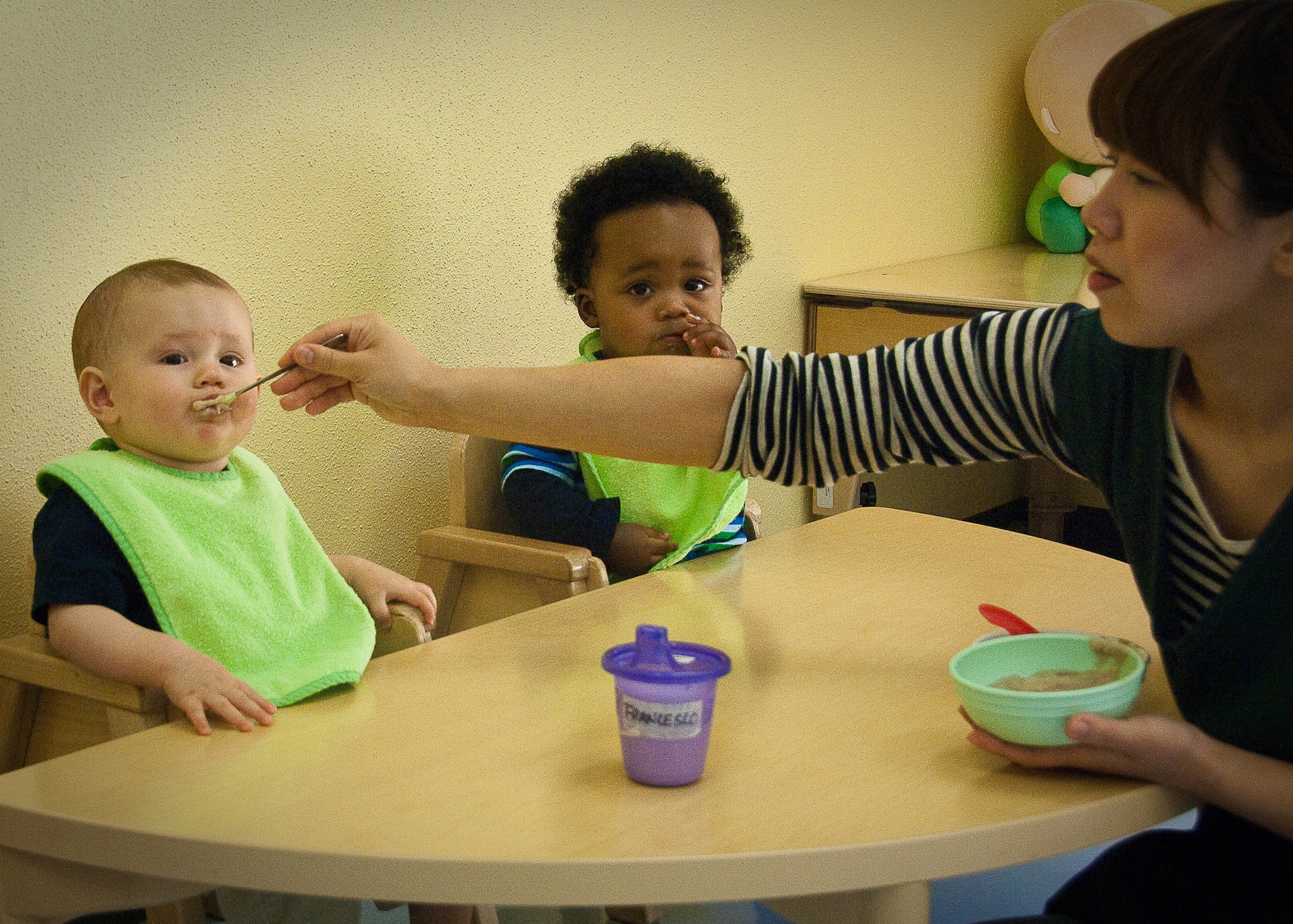 YOKOTA AIR BASE, Japan -- Asumi Sato, a caregiver at the Yume Child Development Center, feeds two children here April 12. Caregivers at the Yume and Kibo CDCs work together to continue normal routines with the children by carrying on everyday activities. (U.S. Air Force photo/Airman 1st Class Lynsie Nichols)