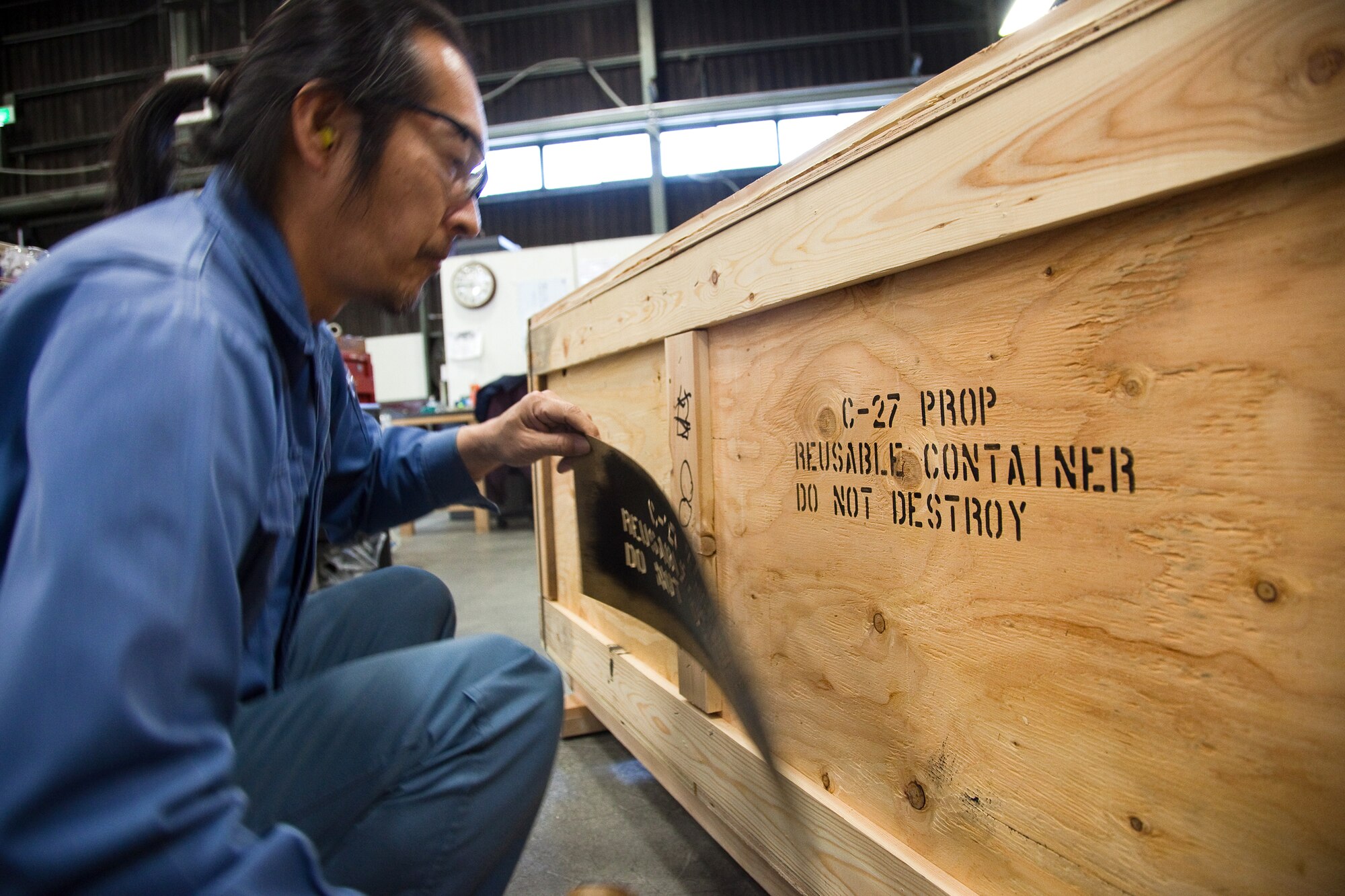 YOKOTA AIR BASE, Japan -- Katsuo Takahara, 374th Logistics Readiness Squadron, marks a custom-made wooden crate, April 12, 2011 at Yokota Air Base, Japan. This is a multi-national movement of 45 C-27 blades and parts originating from the Japan Maritime Self-Defense Force Kisarazu Depot to Afghan C-27 fleet. Team Yokota takes role of fabricating 15 wooden shipping containers for shipping to Afghanistan.  (U.S. Air Force photo/Osakabe Yasuo)