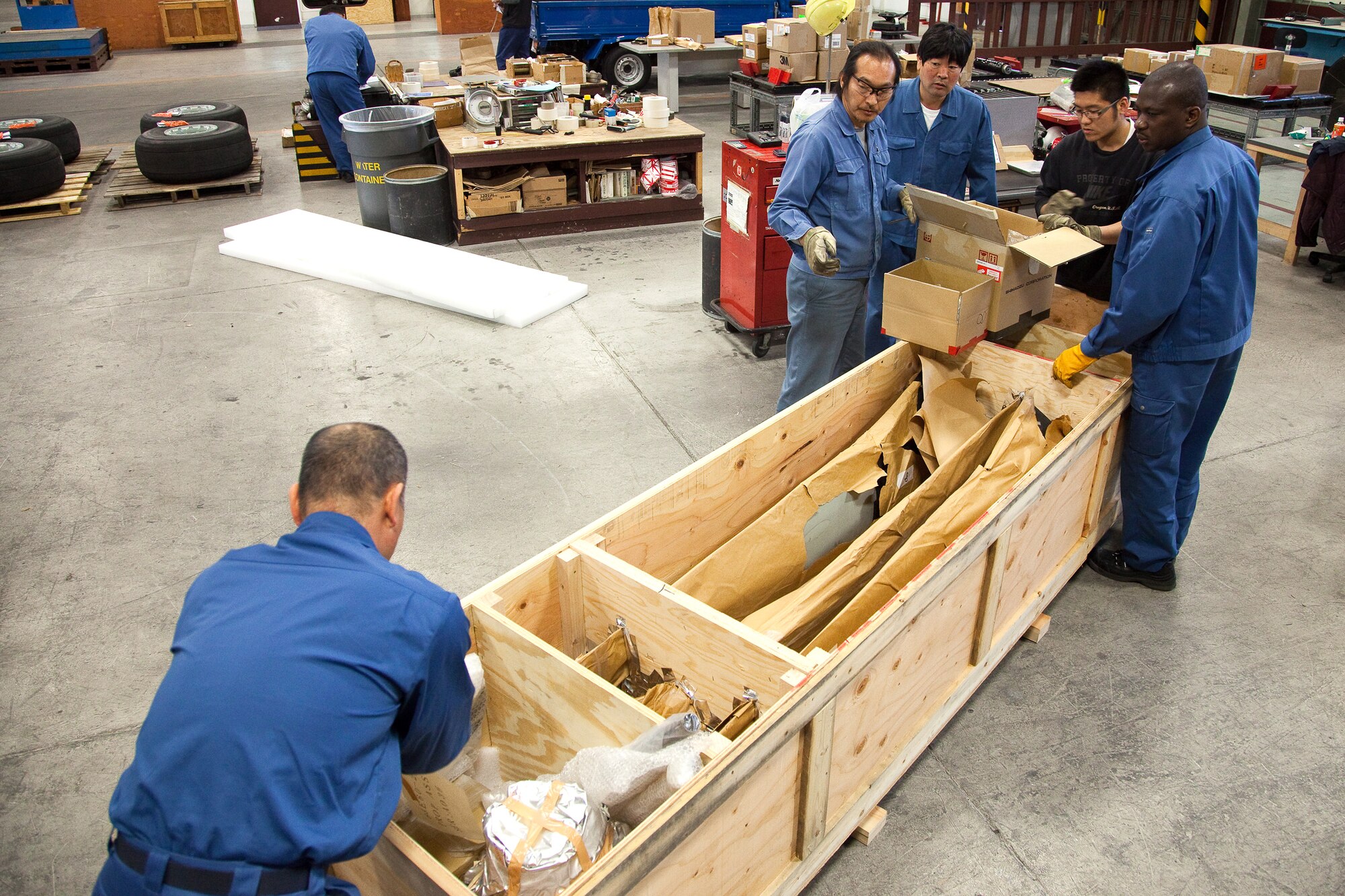 YOKOTA AIR BASE, Japan -- Members of the 374th Logistics Readiness Squadron pack C-27 propellers into a custom-made wooden crate, April 12, 2011 at Yokota Air Base, Japan. This is a multi-national movement of 45 C-27 blades and parts originating from the Japan Maritime Self-Defense Force Kisarazu Depot to Afghan C-27 fleet. Team Yokota takes role of fabricating 15 wooden shipping containers for shipping to Afghanistan.  (U.S. Air Force photo/Osakabe Yasuo)