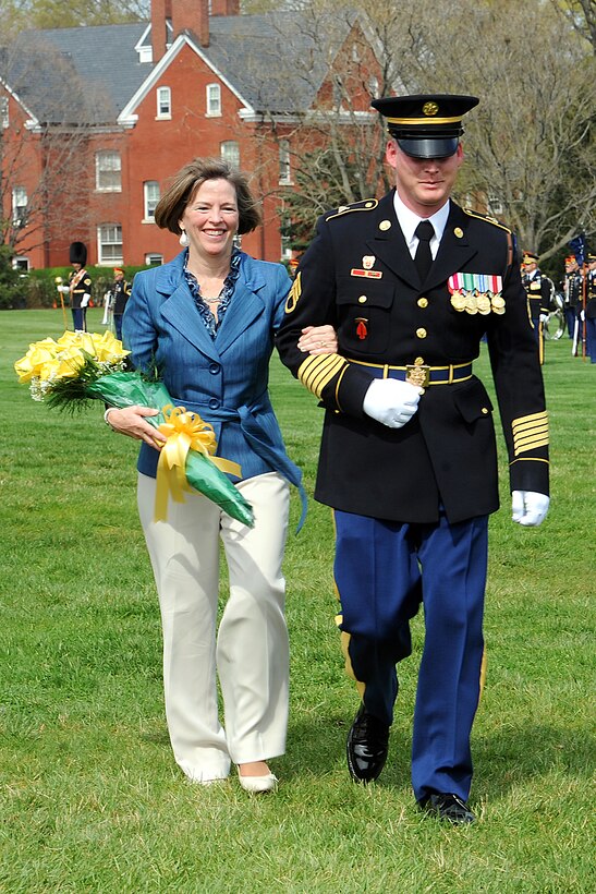 Deanie Dempsey, wife of Army Chief of Staff Gen. Martin E. Dempsey, is escorted back to her seat after receiving flowers during an arrival and swearing-in ceremony on Fort Myer, Va., April 11, 2011.