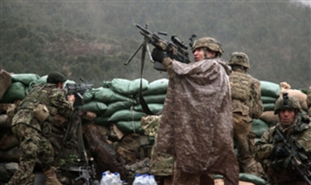 A U.S. Army soldier with the 101st Airborne Division returns fire with a M249 light machine gun during combat operations in the valley of Barawala Kalet, Kunar province, Afghanistan, on March 29, 2011.  