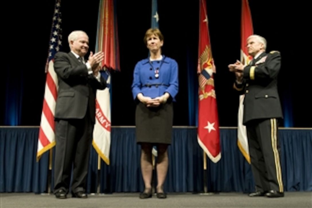 Secretary of Defense Robert M. Gates (left) and Chief of Staff of the Army Gen. George Casey Jr. lead applause to recognize the service of Sheila Casey during a retirement ceremony in the Pentagon on Apr. 11, 2011.  