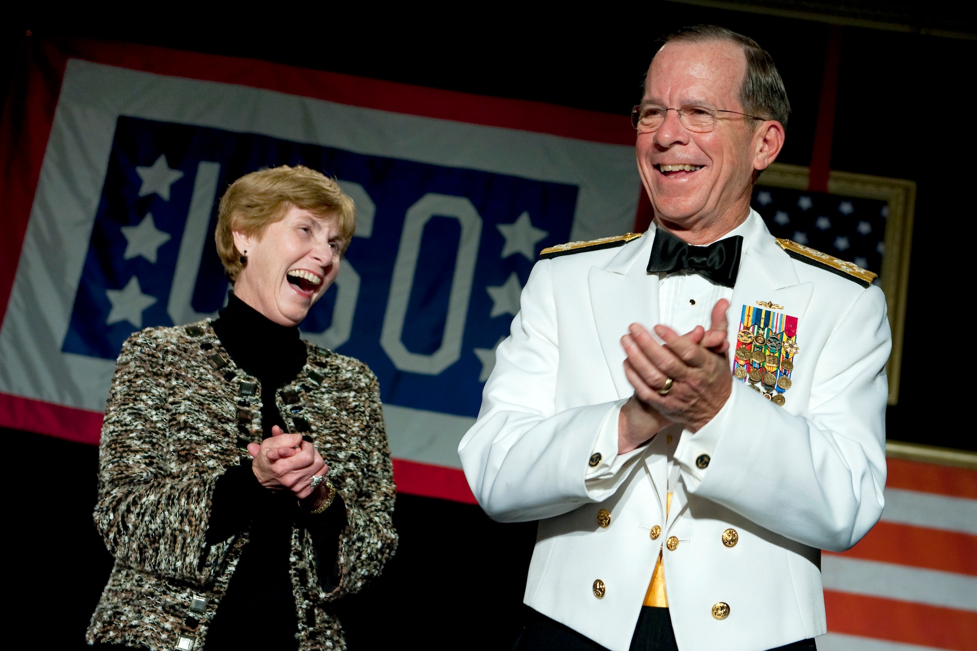 Navy Adm. Mike Mullen, chairman of the Joint Chiefs of Staff, and his wife, Deborah, share a laugh during the 2011 USO Metro Awards Dinner in Washington April 12, 2011. (Defense Department photo/Petty Officer 1st Class Chad J. McNeely)