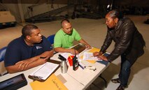 Barry Martin and Rey Rivera, 94th Logistics Readiness Squadron, discuss a C-130H2 flight manifest containing Junior Reserve Officer Training Corps cadets with Lena Bell from the 94th Operations Group, Apr 12.  Miss Bell played an important part in helping the 94th Airlift Wing and Dobbins Air Reserve Base host more than 1,500 high school JROTC cadets for a look at the Wing and a familiarization flight on a C-130H2 Hercules aircraft.   (U.S. Air Force photo/ Brad Fallin)