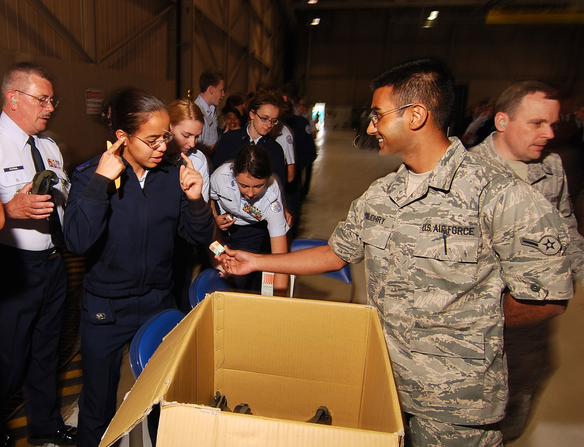 Airman Shehroze Choudhry, 94th Maintenance Squadron, passes out safety items such as goggles, ear plugs, and air sickness bags to Junior Reserve Officer Training Corps cadets from the Atlanta regional area prior to their flight on a C-130H2 Hercules, Apr 12.  The 94th Airlift Wing and Dobbins Air Reserve Base hosted more than 1,500 high school JROTC cadets for a look at the Wing and a familiarization flight on its cargo aircraft.   (U.S. Air Force photo/ Brad Fallin)