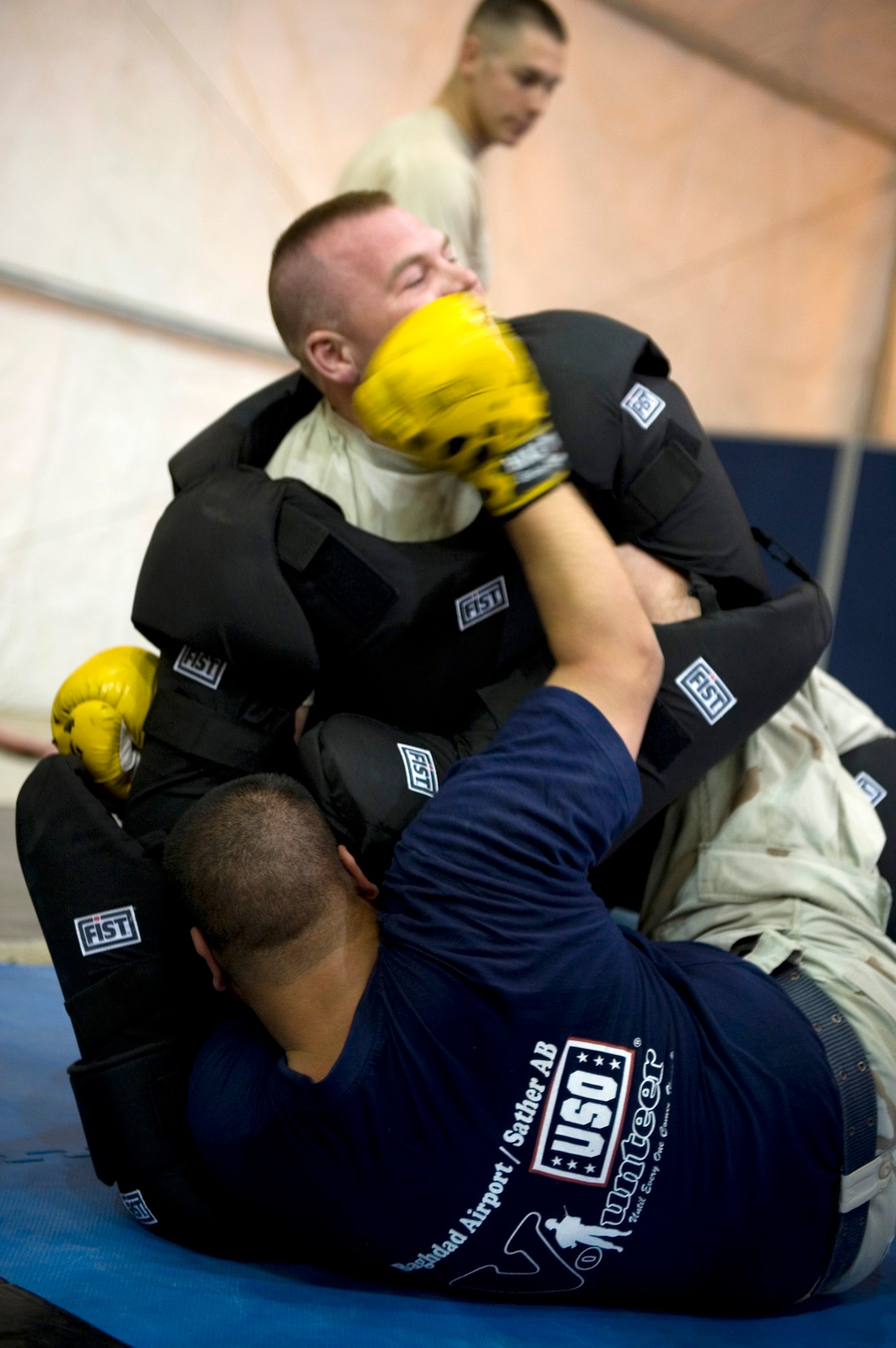 Staff Sgt. Branden Gallacher (top) grapples with an Iraqi airman April 8, 2011. Members of the 447th Eexpeditionary Security Forces Sqaudron trained Iraqi security forces airmen ensuring weapons qualification and teaching defensive tactics, vehicle searches and other force protection measures. Sergeant Gallacher is assigned to the 447th ESFS. (U.S. Air Force photo/Staff Sgt. Levi Riendeau)
