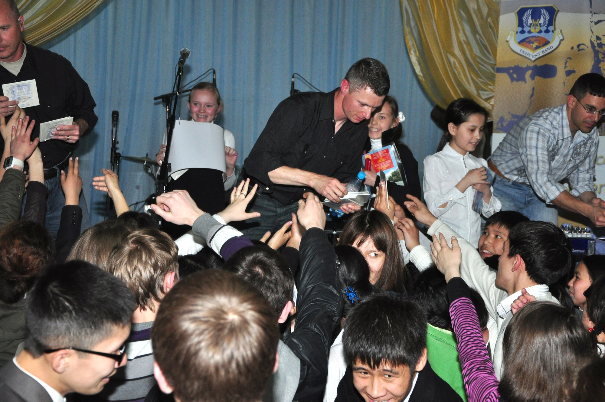 Tech. Sgt(s) Tim Stombaugh and Jeff Valentine give students CDs April 1, 2011, at a school in Bishkek, Kyrgyzstan, after their performance. (U.S. Air Force photo/Master Sgt. Daniel Nathaniel III) 