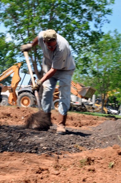 A contractor from a concrete construction company shovels gravel during construction of a new sidewalk on Barksdale Air Force Base, La., April 13. The construction company is based out of Winnsboro, La. They specialize in roads, highways and sidewalks. (U.S. Air Force photo/Senior Airman Brittany Y. Bateman)(RELEASED)