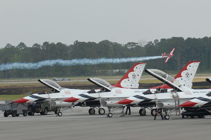 Greg Poe, an aerobatic performer flies his Ethanol-Powered Fagen MX2, over the U.S. Thunderbirds across air show central during the Charleston Air Expo 2011 Apr. 9. All the demonstrators displayed their precision flying for nearly 80,000 people during the Expo. (U.S. Air Force photo by Tech. Sgt. Chrissy Best)
