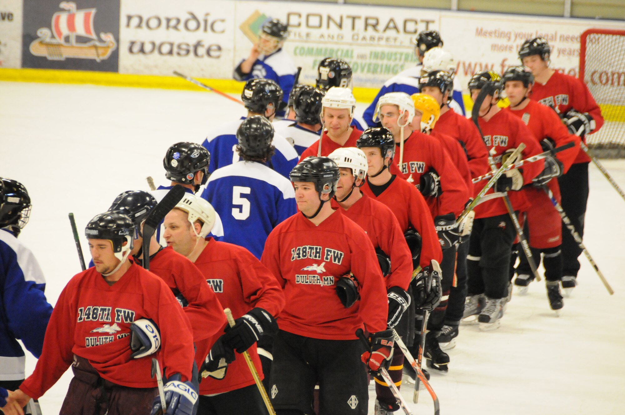 Players from the 148th Fighter Wing, Duluth, Minn. (red uniforms) and 133rd Airlift Wing, St. Paul, Minn. (blue uniforms) shake hands at the conclusion of their hockey game.  The two teams were participating in the 2011 Minnesota National Guard hockey tournament held at the Duluth Heritage Sports Center in Duluth, Minn.  (U.S. Air Force photo by Master Sgt. Ralph J. Kapustka)