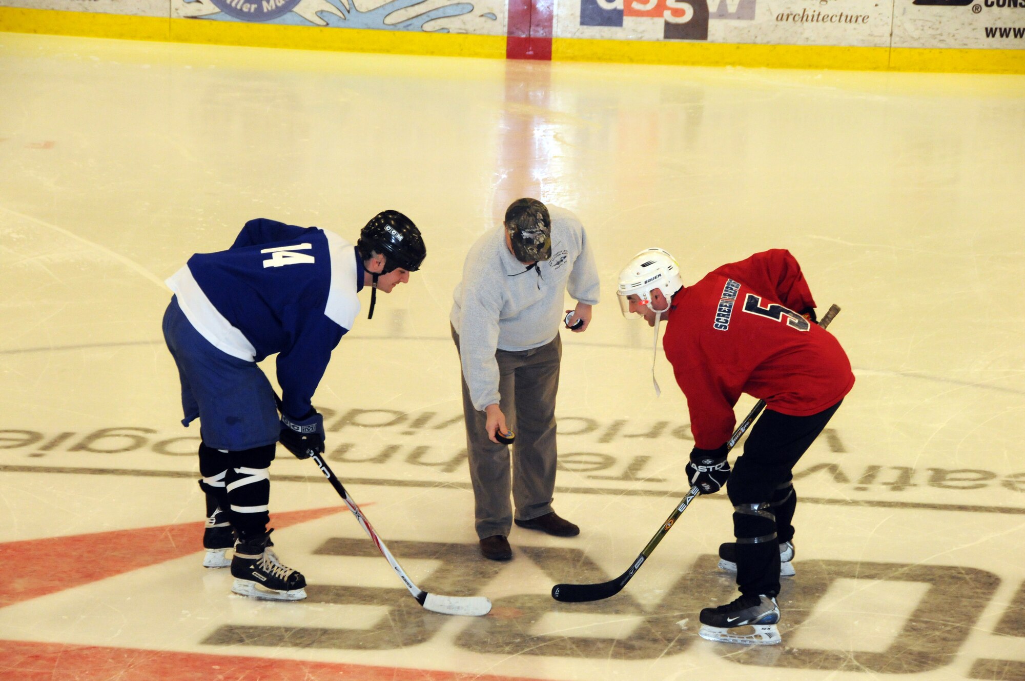 Col. Steven Wabrowetz,148th Fighter Wing, Maintenance Group Commander drops the ceremonial puck to signify the start of the Minnesota National Guard hockey tournament.  The tournament was held at the Duluth Heritage Sports Center in Duluth, Minn.  (U.S. Air Force photo by Master Sgt. Ralph J. Kapustka)