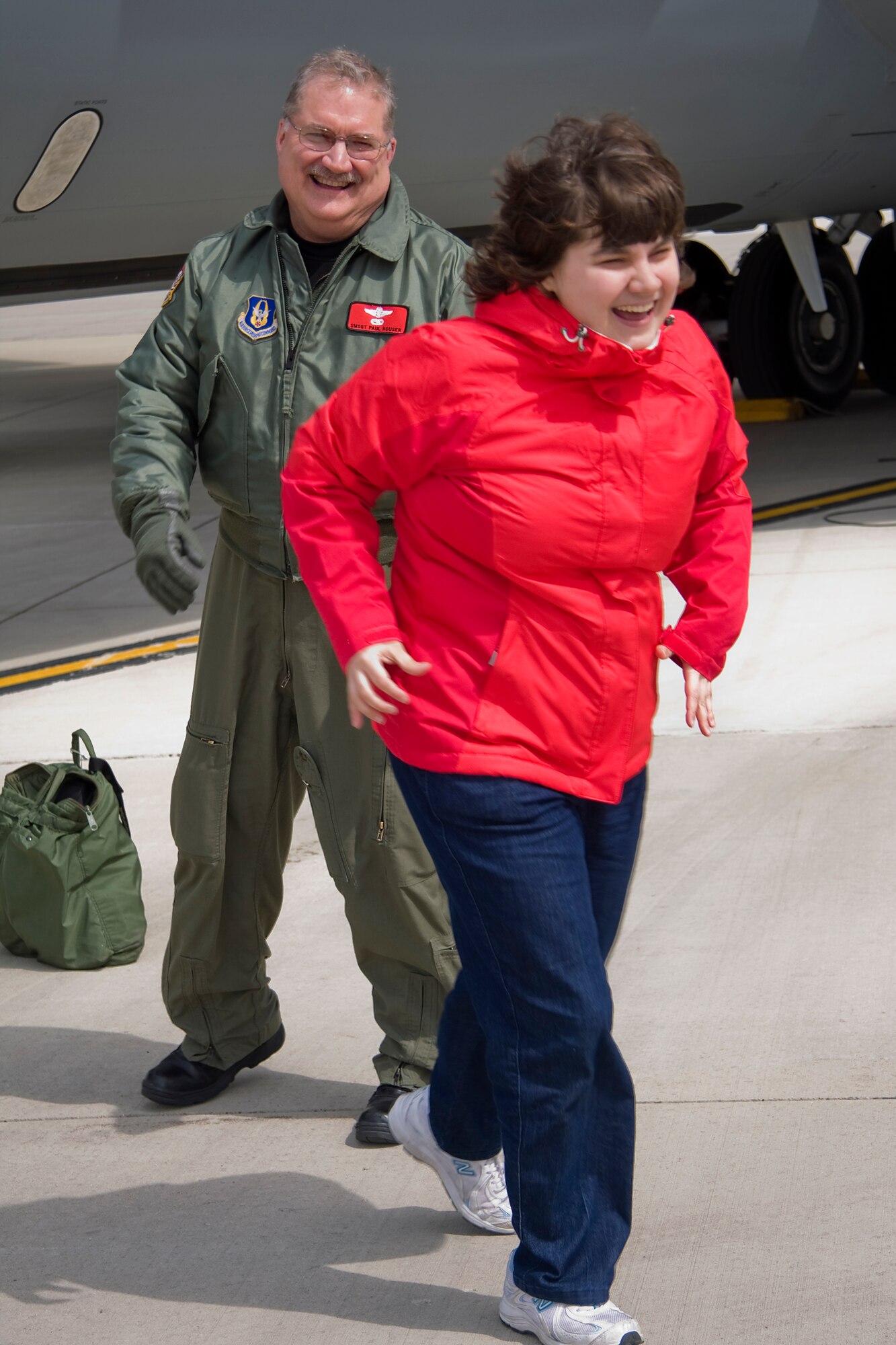 GRISSOM AIR RESERVE BASE, Ind. --  Laura Houser excitedly walks away to rejoin her family after racing out to hug her dad, Senior Master Sgt. Paul "Doogie" Houser, shortly after he landed at Grissom completing his 10,000th flight hour April 5. Sergeant Houser was greeted by friends, family and coworkers after achieving this milestone while refueling a B-52 from the 307th Bomb Wing at Barksdale Air Force Base, La. Sergeant Houser is an in-flight refueling manager and instructor boom operator with the 434th Operations Support Squadron.  (U.S. Air Force photo/Tech. Sgt. Mark R. W. Orders-Woempner)

