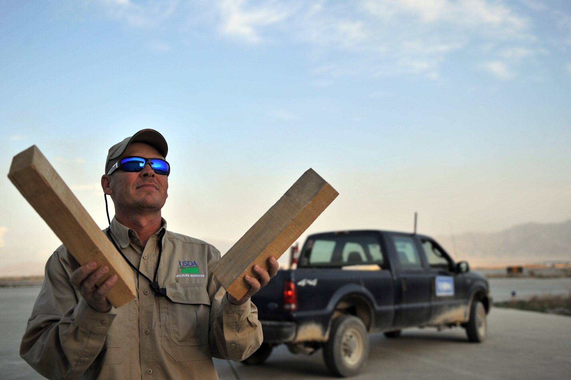 Mr. Eddie Earwood, U.S. Department of Agriculture Wildlife Services biologist, uses a clap-board method to disband birds that have been lingering in or around the hangars at Bagram Airfield, Afghanistan, April 13, 2011. Mr. Earwood, assigned to the 455th Air Expeditionary Wing Safety, routinely checks different locations on and around the flightline to ensure there are no potential health and safety hazards. (U.S. Air Force photo by Senior Airman Sheila deVera)