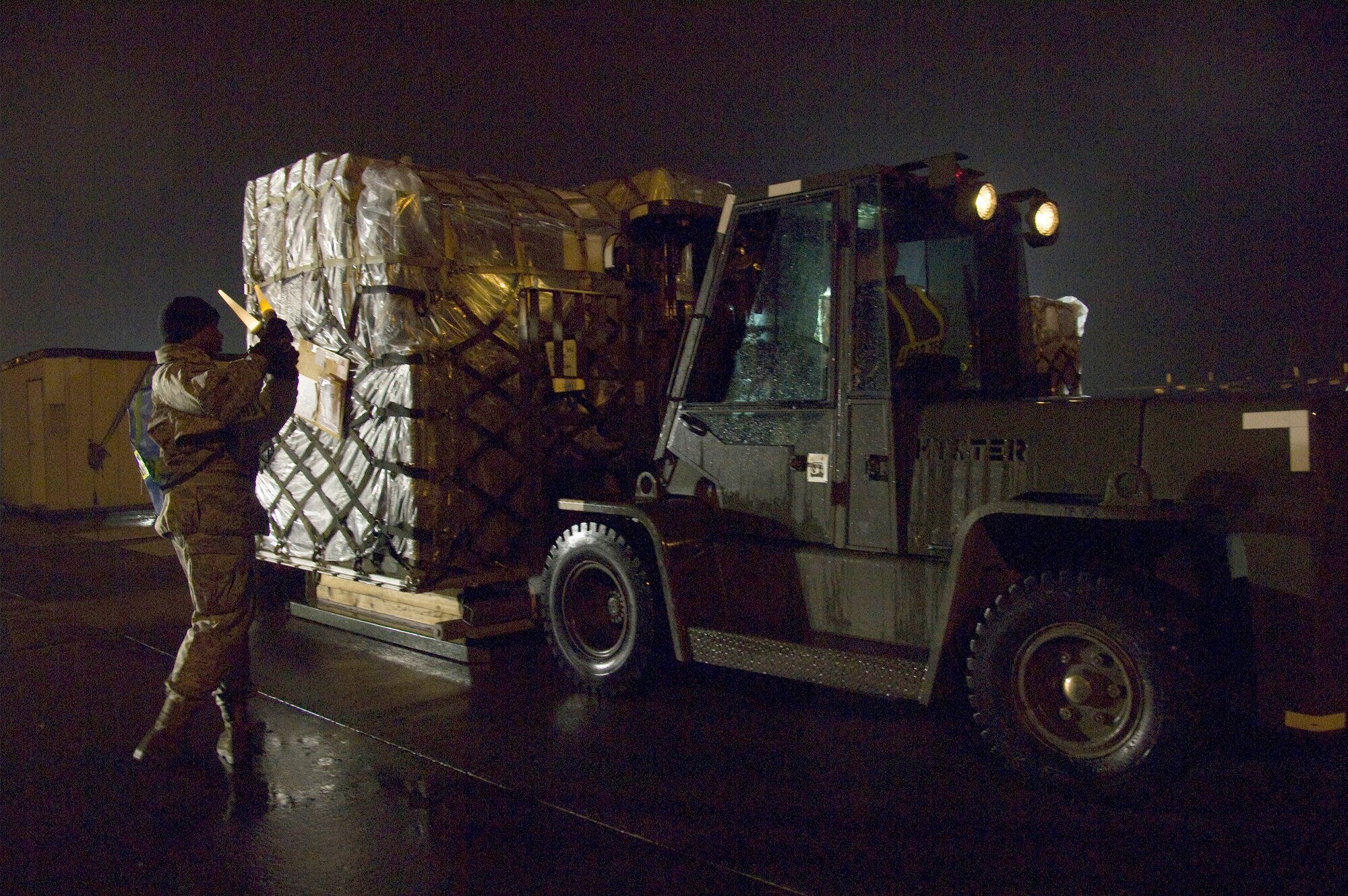 Airman 1st Class Jarrett Hunt guides a forklift carrying a medical cargo pallet during an operational readiness exercise March 7, 2011, at Yokota Air Base, Japan. Airmen from the 374th Maintenance Squadron moved multiple pallets of essential cargo during the exercise to ensure mission readiness. Airman Hunt is an aerospace propulsion apprentice assigned to the 374th MXS. (U.S. Air Force photo/Airman 1st Class Andrea Salazar)