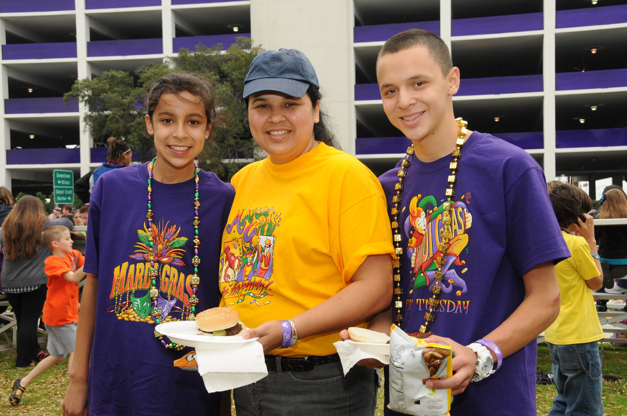 Dora Gelacio, center, wife of Tech. Sgt. Jesus Gelacio, 81st Logistics Readiness Squadron, is letting the good times roll with her daughter, Michelle, 13, and son Alex, 17, at the Mardi Gras parade in Biloxi, March 8. With Sergeant Gelacio currently deployed to Kuwait, his family attends a picnic at the Biloxi Town Green for families of deployed service members sponsored by the airman and family readiness center.  (U.S. Air Force photo by Kemberly Groue)
