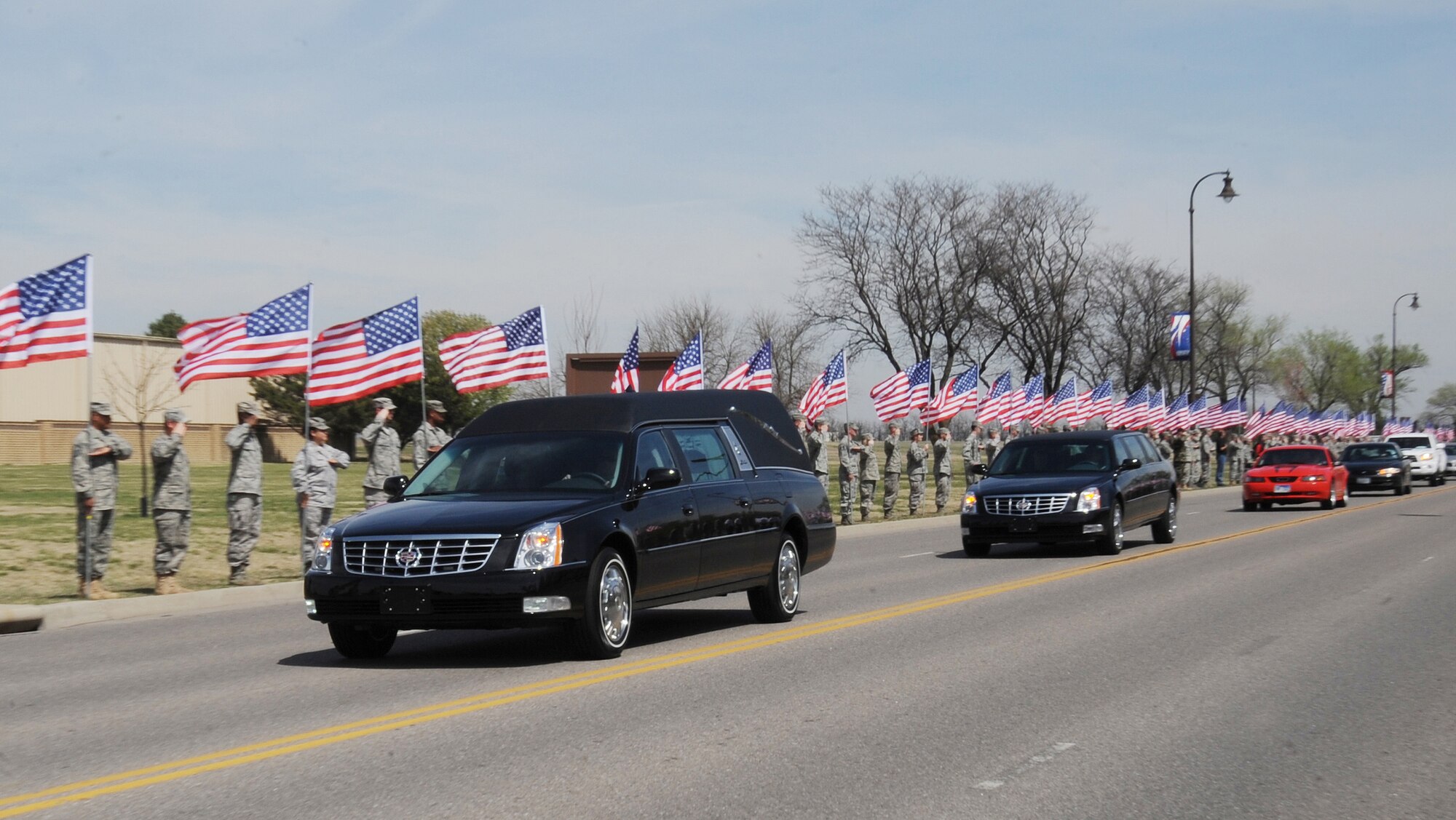 More than 600 Team McConnell members provide honors to Tech. Sgt. Harold “Luke” Young, 22nd Maintenance Squadron, and his family April 7, 2011, McConnell Air Force Base, Kan. Sergeant Young perished in a motorcycle accident April 3. The American Legion Riders escorted the funeral procession, and supplied American flags to Team McConnell members. (U.S. Air Force photo/Airman 1st Class Katrina M. Brisbin)