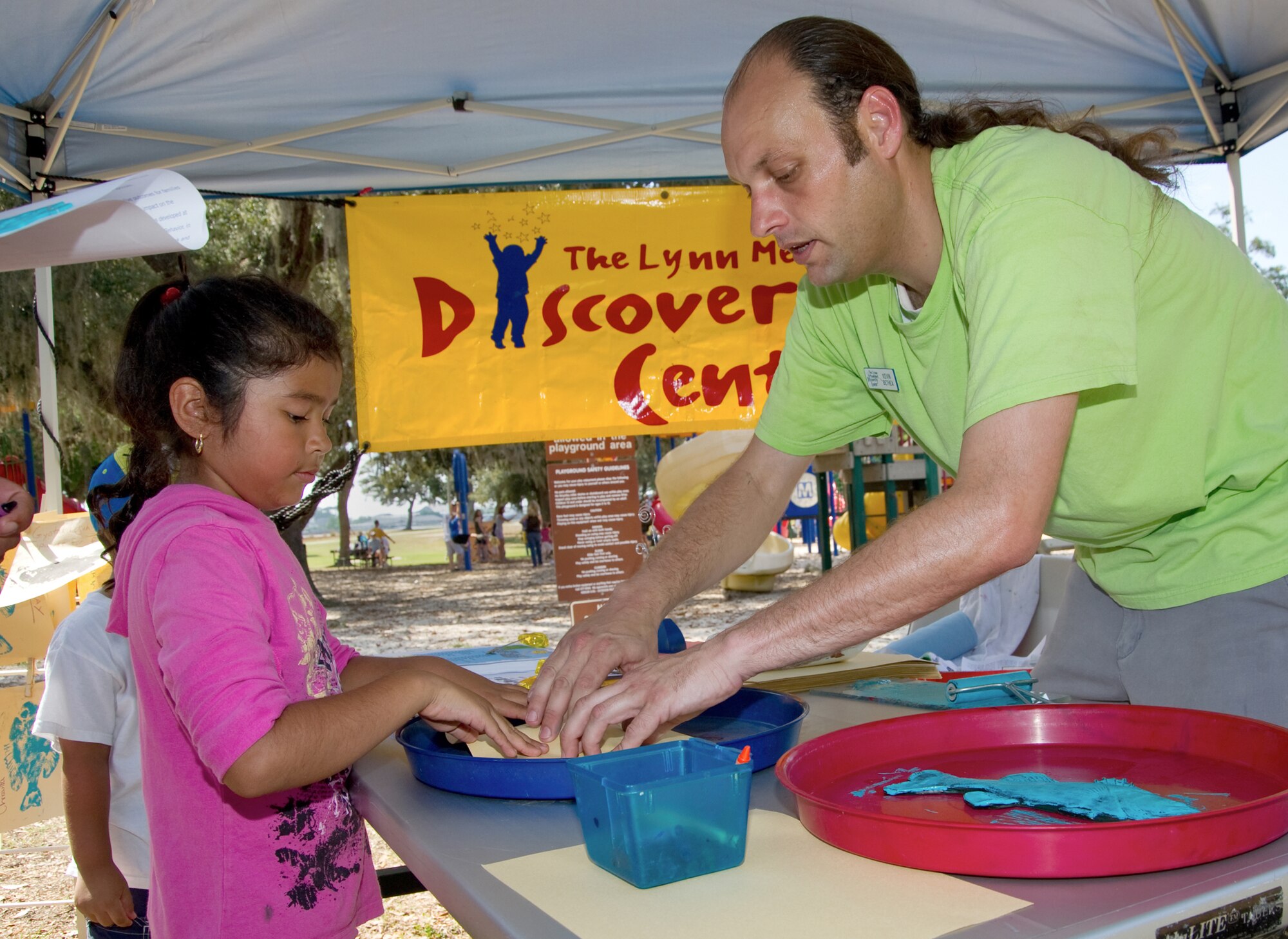 Emily Mederos, 7, works with Kevin Bethea, director of museum experiences at the Lynn Meadows Discovery Center, on a paint rubbing impression.  Emily is the daughter of Master Sgt. Juan and Maria Mederos, 332nd TRS.  (U.S. Air Force photo by Adam Bond)