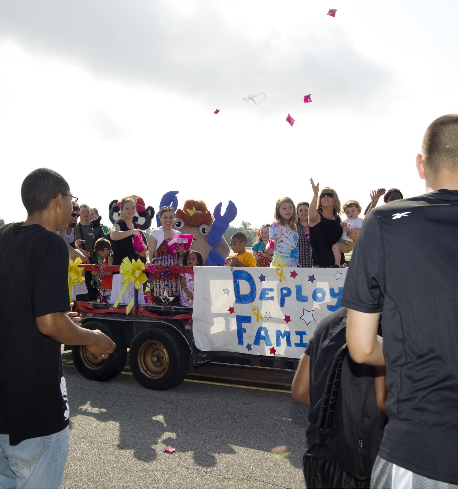 A parade kicked off a fun-filled Child Pride Day at Keesler Saturday. In this float, deployed family members toss candy and beads to the crowd lining the parade route.  (U.S. Air Force photo by Adam Bond)