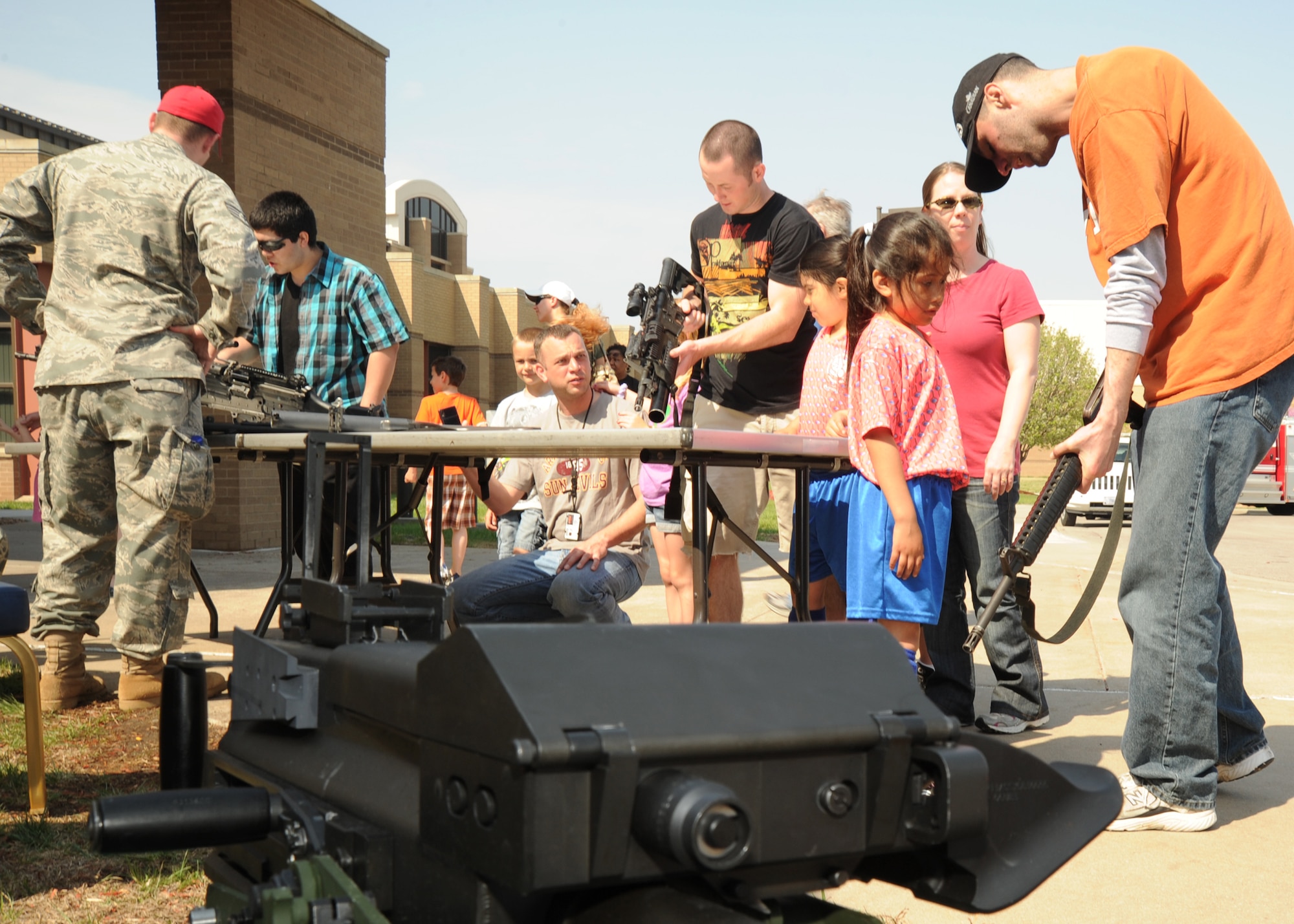 Team McConnell family members view different firing weapons at the combat arms table during the Family Festival of Fun April 9, 2011, McConnell Air Force Base, Kan. During the festival, different base organizations displayed their unit’s equipment and spoke about their mission to military families to promote the “Month of the Military Child.” Wing personnel and their families were given the opportunity to participate in family activities including pony rides, face painting and arts and crafts. (U.S. Air Force photo/Senior Airman Maria A. Ruiz)