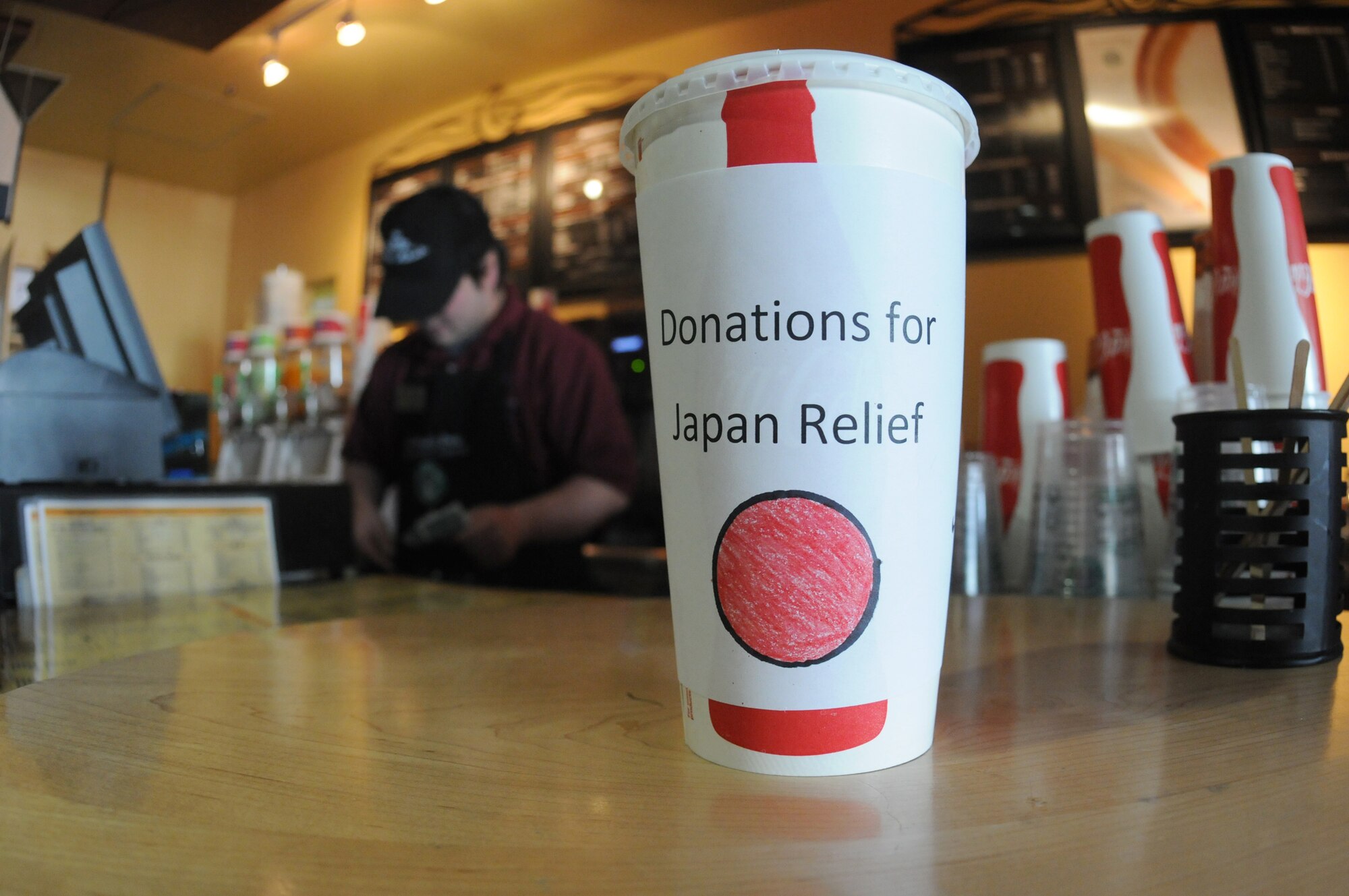 A cup displaying a representation of the Japanese sun and the words, "Donations for Japan relief," sits on the counter April 5, 2011, at the cafe at Misawa Air Base, Japan. The baristas there unanimously decided to donate any tips made since March 11 to aid Japan relief efforts, and on April 5, the cafe managers handed a $1,691 check to Misawa's Red Cross station. (U.S. Air Force photo/Senior Airman Joe McFadden)