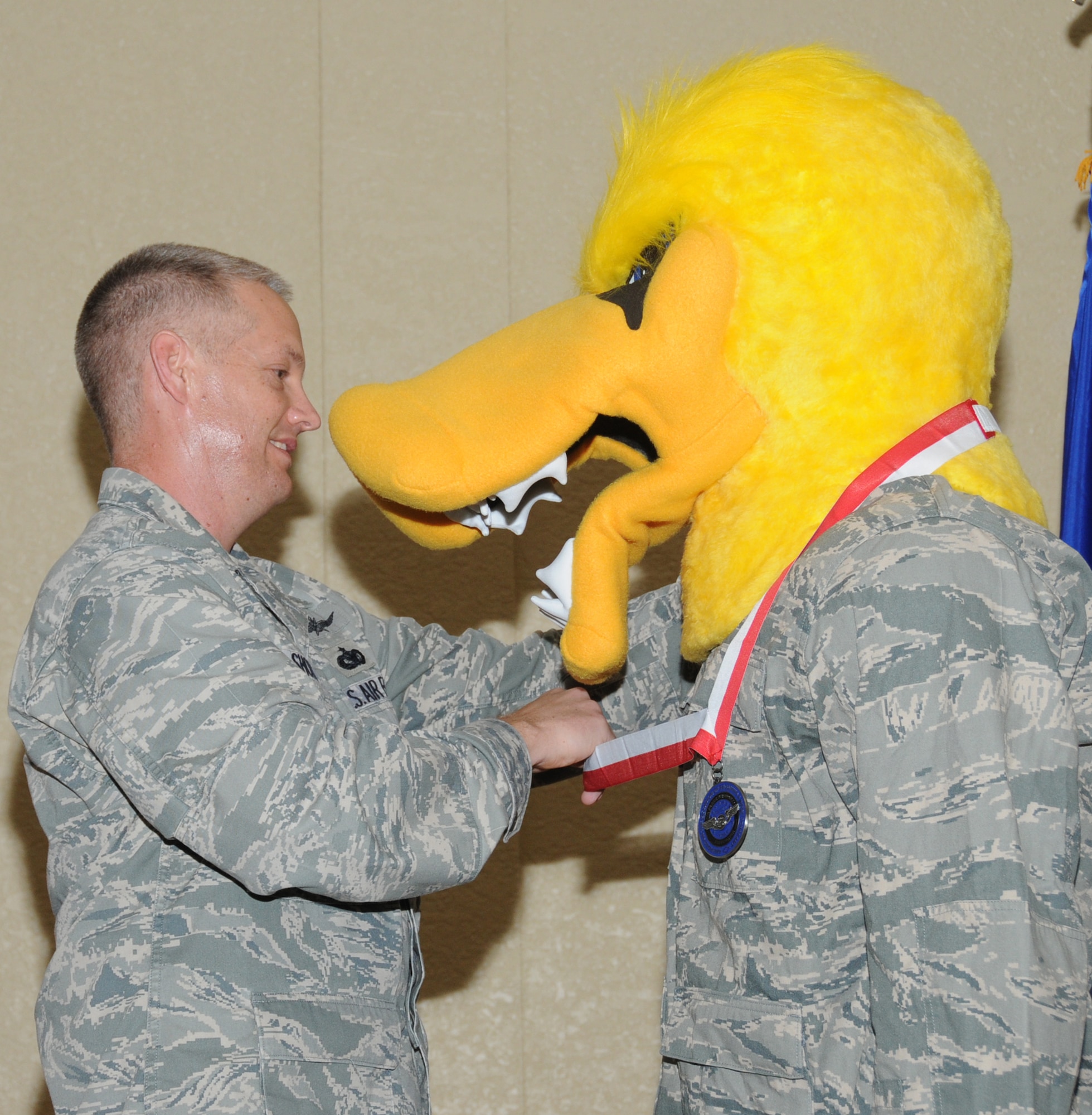 Lt. Col. Douglas Short, 333rd Training Squadron commander, presents Mad Duck,
333rd TRS mascot, the Meritorious Mascot Medal and letter of appreciation during its
retirement ceremony at the Bay Breeze Event Center during a 333rd TRS commander’s call April 8. The Spartan was welcomed as the new mascot.  (U.S. Air Force photo by Kemberly Groue)
