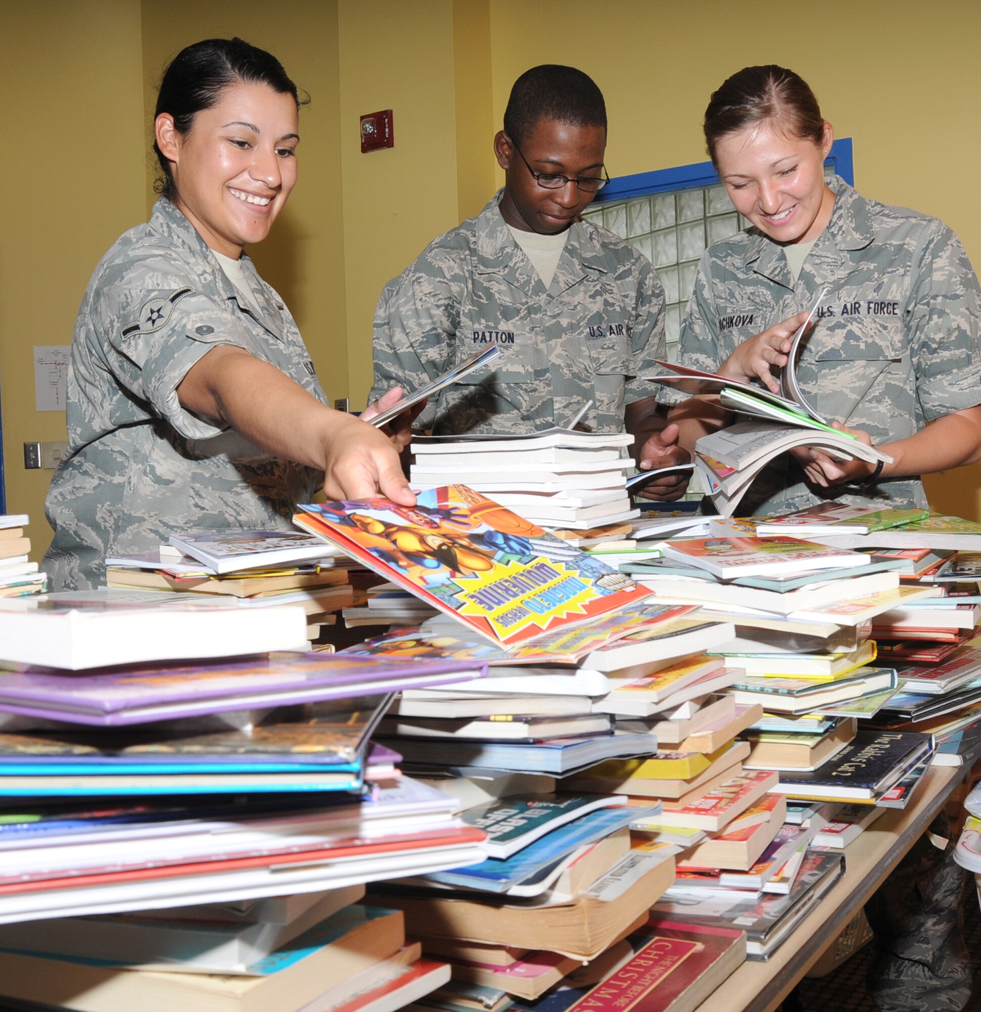 From left, Airman Priscilla Lugo and Airmen Basic Mark Patton and Ekaterina Bochkova, students in the 336th Training Squadron, sort books into age-appropriate sections Monday after a squadron book drive that netted 1,470 books for children and classroomlibraries at the child development center, youth center and family child care homes. The drive was spearheaded by Staff Sgt. Twan Jennings, a 336th TRS instructor and member of the CDC’s parent advisory board after learning of the center’s book swap program.  (U.S. Air Force photo by Kemberly Groue)