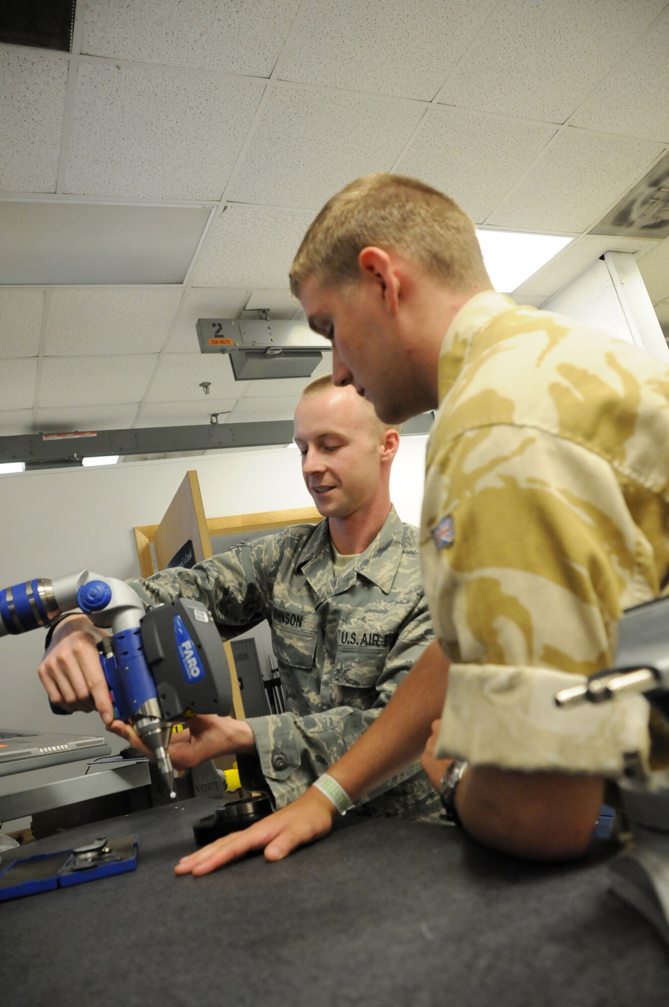 MacDill Air Force Base, Fla. -- Staff Sgt. Michael Johnston, an aircraft metals technology machinist, scans the hand of British Air Cadet Aaron Thompkins, of Enfield, Britain.  Johnston demonstrated the Air Force's ability to scan a piece of equipment, or a human hand, into a computer system so it could be engineered and re-created.  Fifteen cadets and 7 staff members from the British Royal Air Force Cadet program toured Macdill for a day, learning about the Air Force Reserve. 