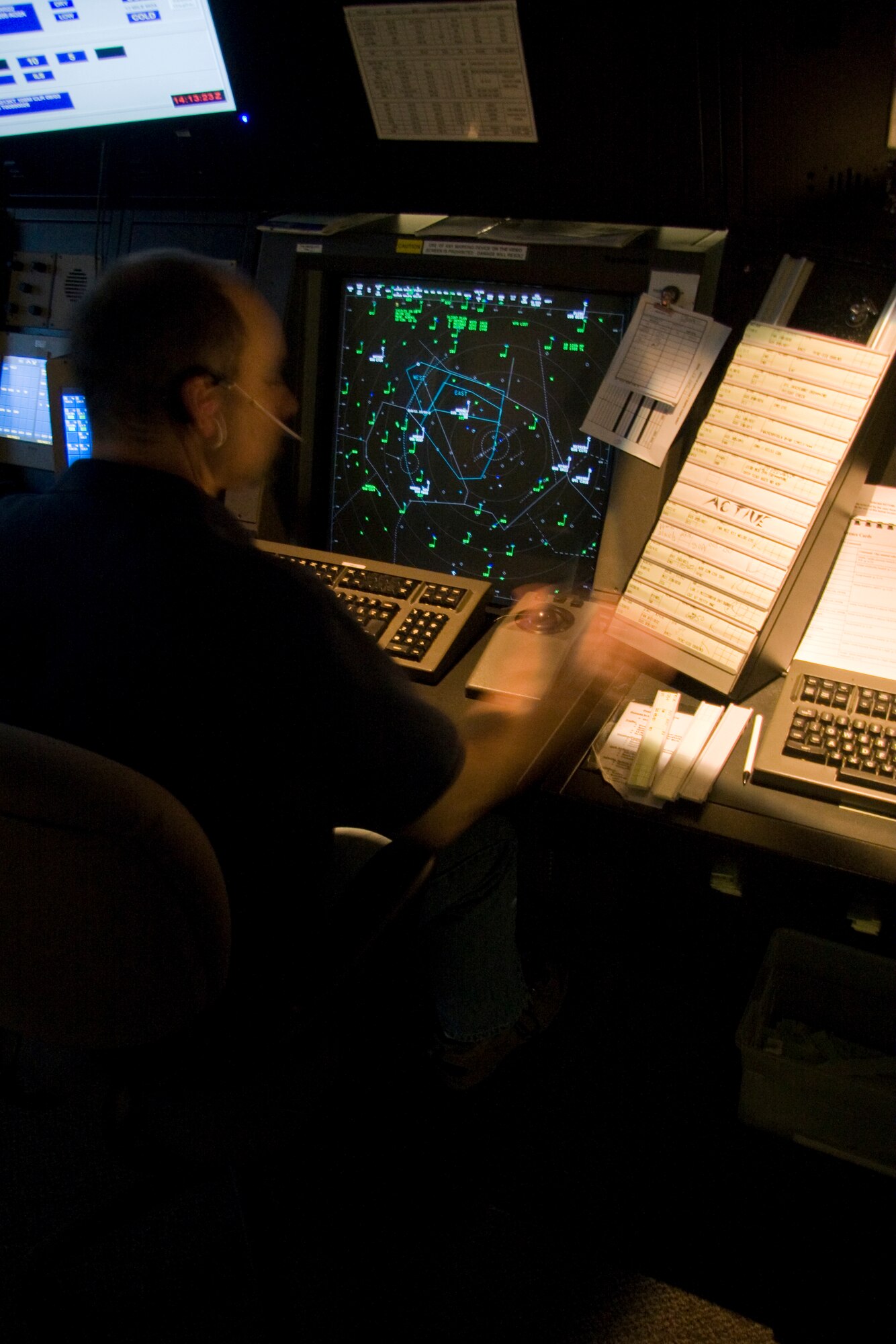 GRISSOM AIR RESERVE BASE, Ind. -- In a blur of speed and precision, Jon Holz manages civilian and military aircraft above Grissom Air Reserve Base, Ind., April 12 in Grissom's radar approach control facility. Mr. Holz is an ATC specialist assigned to the 434th Operations Support Squadron. ATC specialists like Mr. Holz provide air traffic management for the airspace between Chicago and Indianapolis, going as far west as Lafayette, Ind., up to 10,000 feet 365 days a year. (U.S. Air Force photo/Tech. Sgt. Mark R. W. Orders-Woempner) 
