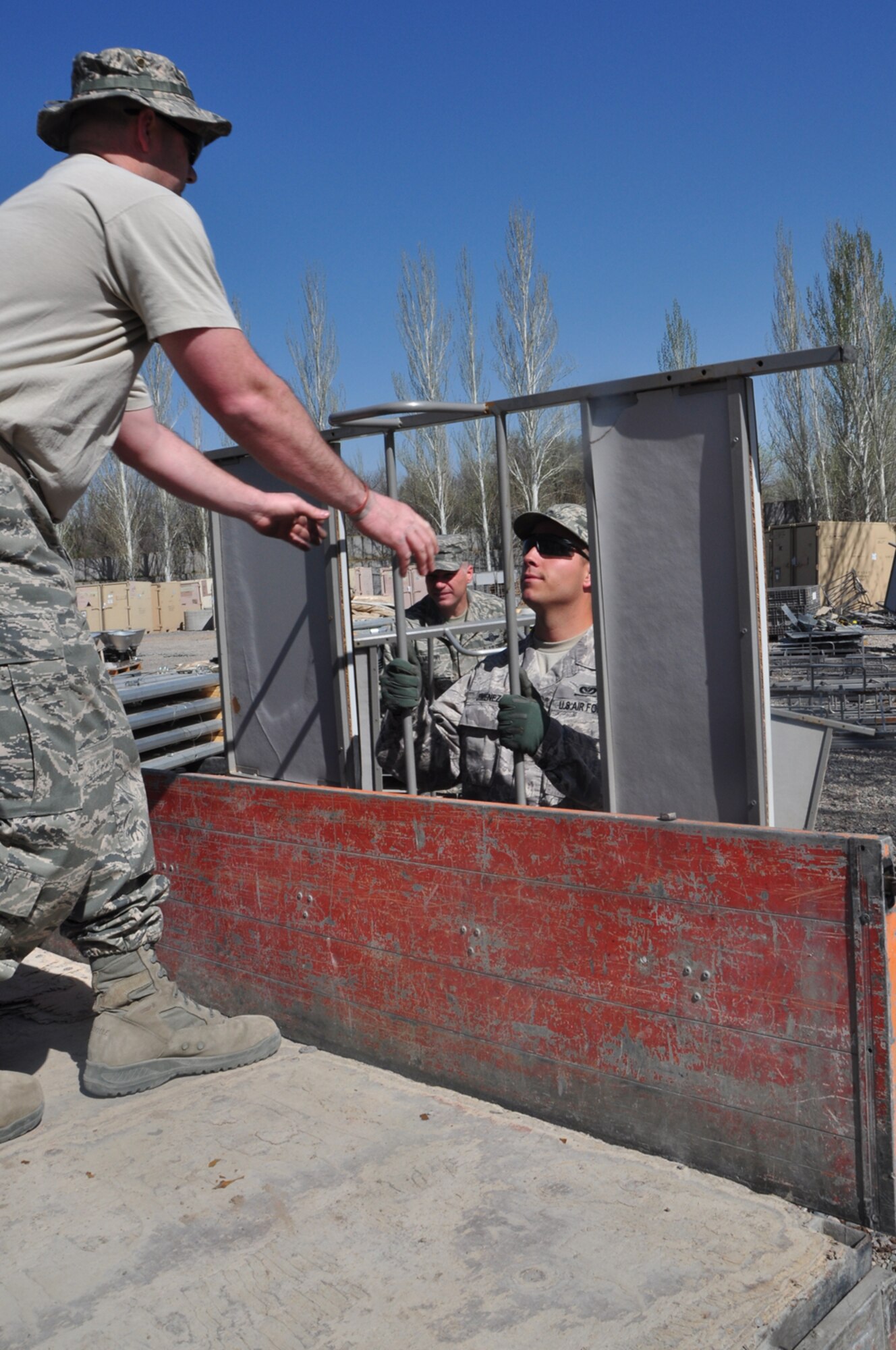 Senior Airman John Jimenez hands a bunk bed unit to Capt. Tim Hall onto a truck with bunk beds headed for donation to the School for the Deaf April 13. The Theater Security Cooperation division here facilitated the transfer of approximately 140 bunk bed units and 70 mattresses that were deemed excess property by the Defense Reutilization and Marketing Office. The School for the Deaf takes in and boards hearing impaired children from all-over Kyrgyzstan teaching them both general and specialized subjects including sign language.