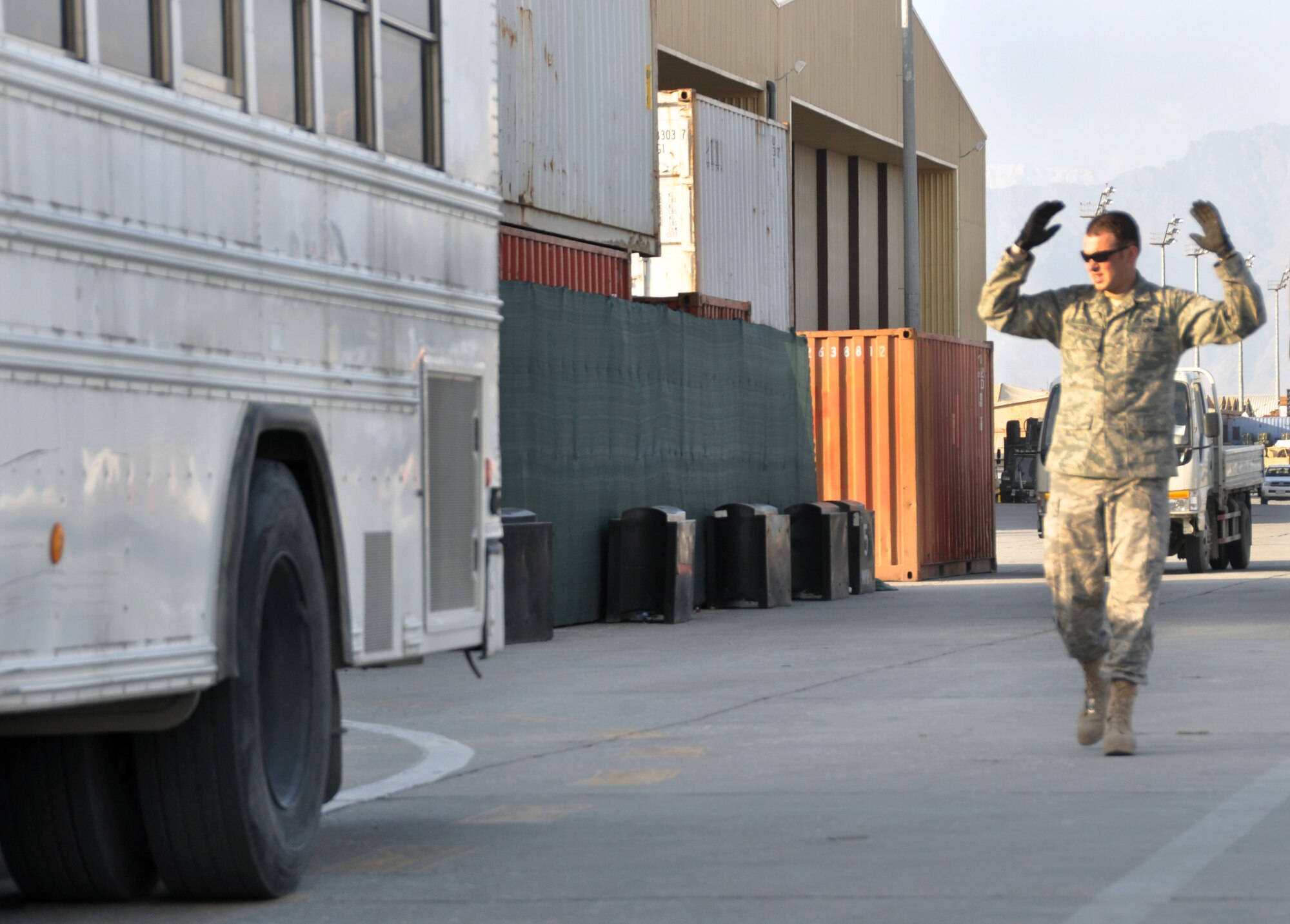 Tech. Sgt. Jason Rictor, 60th Aerial Port Squadron shift supervisor, guides the driver of a passenger bus as they reposition it to better accommodate troops that require movement from the passenger terminal on Bagram Airfield Apr. 12. 