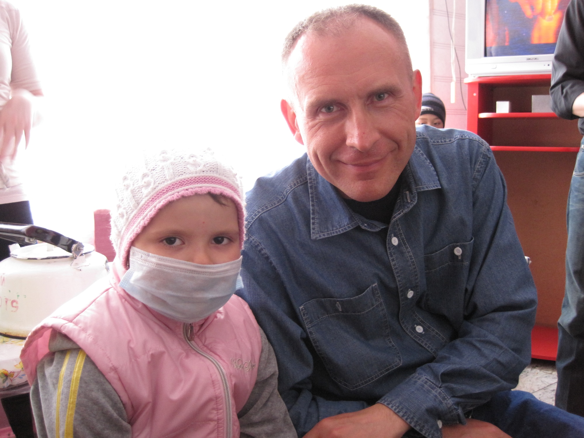 Master Sgt. Janusz Masztalerz visits, in her native Russian tongue, with one of the patients at the Children's Cancer Center in Bishkek, Kyrgyzstan. (U.S. Air Force photo by Master Sgt. Karl Bradley)
