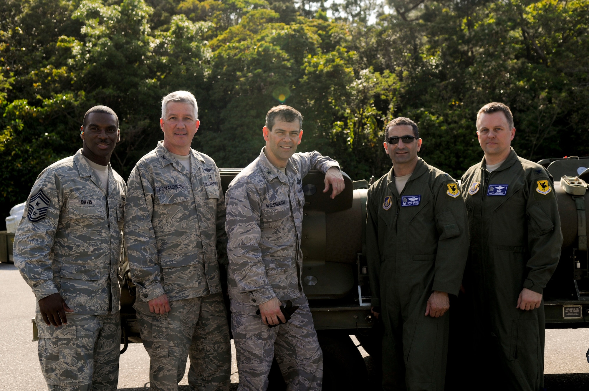 (From left to right) Chief Master Sgt. James Davis, the 18th Wing command chief, Col. Stephen Donaldson, the 18th Air Evacuation Squadron commander, Brig. Gen. Kenneth Wilsbach, the 18th Wing commander, Col. David Nahom, the 18th Operations Group commander and Col. Matthew Molineux, the 18th OG deputy commander, stand in front of the bombs they put together during the 18th MUNS’s Air Force Combat Ammunition Center April 8.  The day was based on the school AMMO troops go to gain their seven and nine level so wing leadership can get hands on experience. (U.S. Air Force photo/ Airman 1st Class Brooke P. Beers)