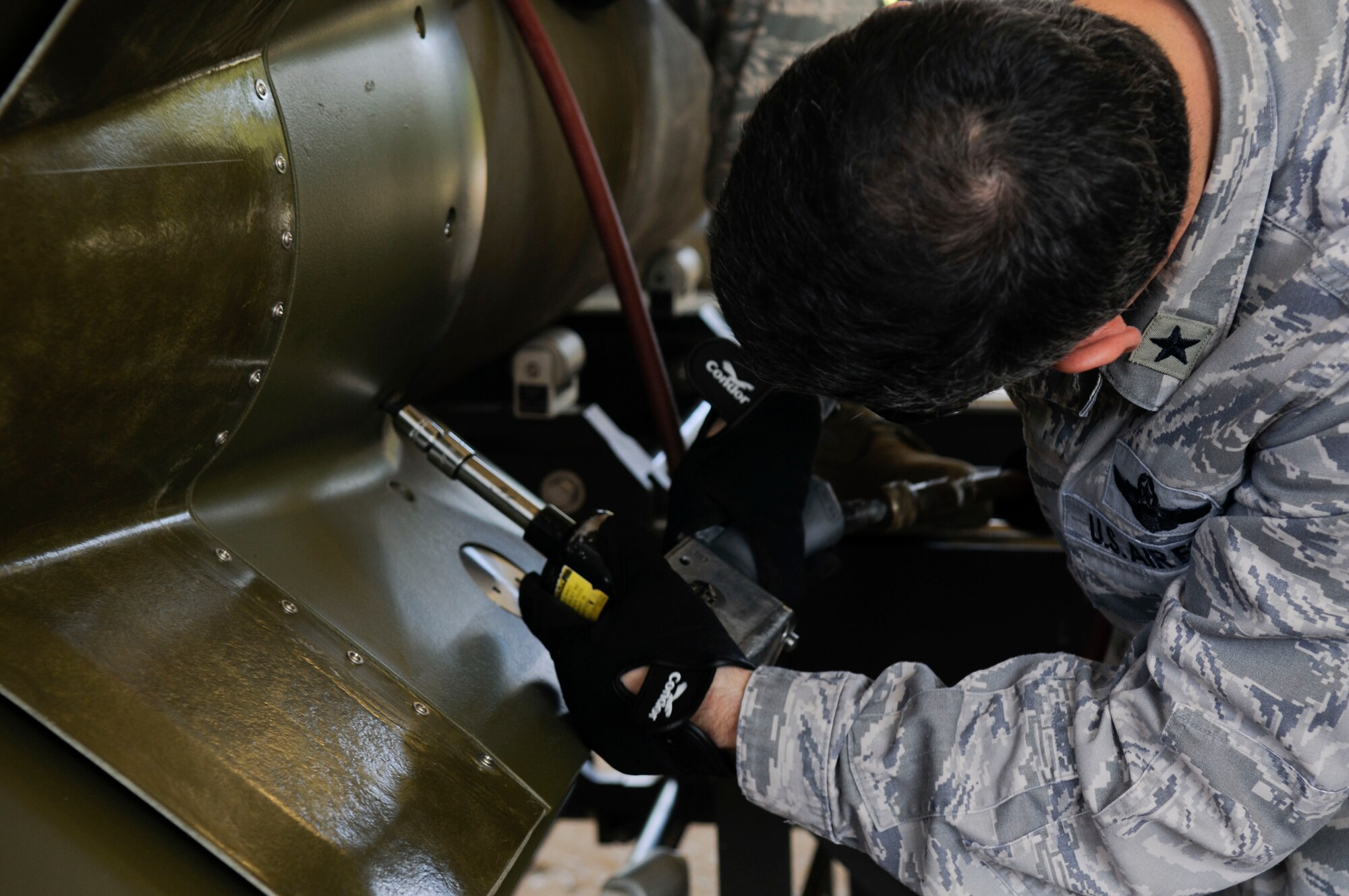 Brig. Gen. Kenneth Wilsbach, 18th Wing commander, bolts parts together while creating bombs at Kadena’s munitions area, April 8. Commanders and leaders from the base were given the opportunity to learn common AMMO skills in order to see what a typical AMMO troop goes through during a wing exercise. (U.S. Air Force photo/Senior Airman Sara Csurilla)