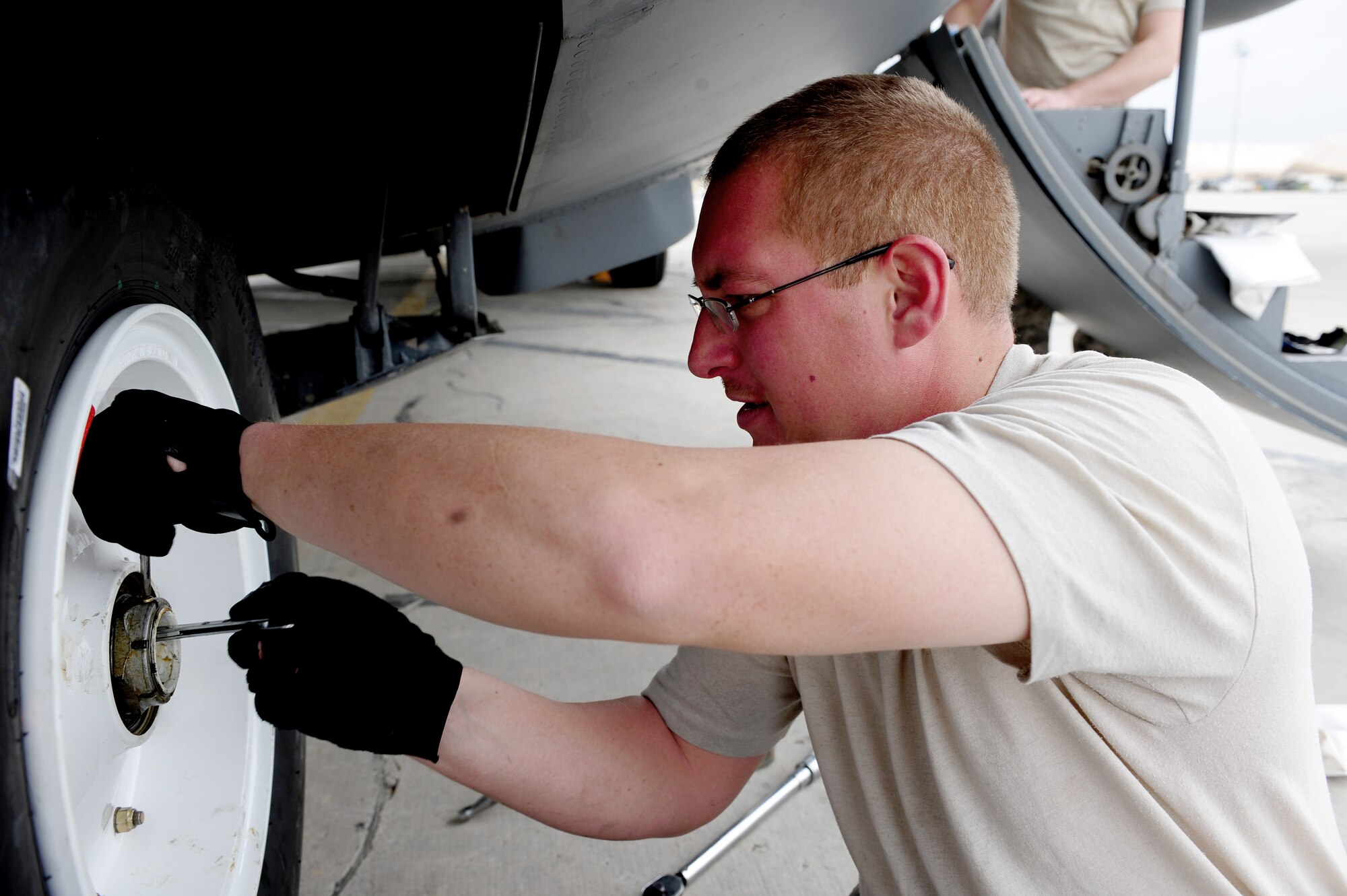 U.S. Air Force Staff Sgt. John Green, 455th Expeditionary Aircraft Maintenance Squadron crew chief, tightens a set screw onto the axel nut during a tire change procedure on a C-130 Hercules aircraft at Bagram Airfield, Afghanistan, April 9, 2011. Green is deployed from the Delaware Air National Guard’s 166th Aircraft Maintenance Squadron, New Castle, Del., supporting Operation Enduring Freedom. (U.S. Air Force photo/Master Sgt. William Greer)