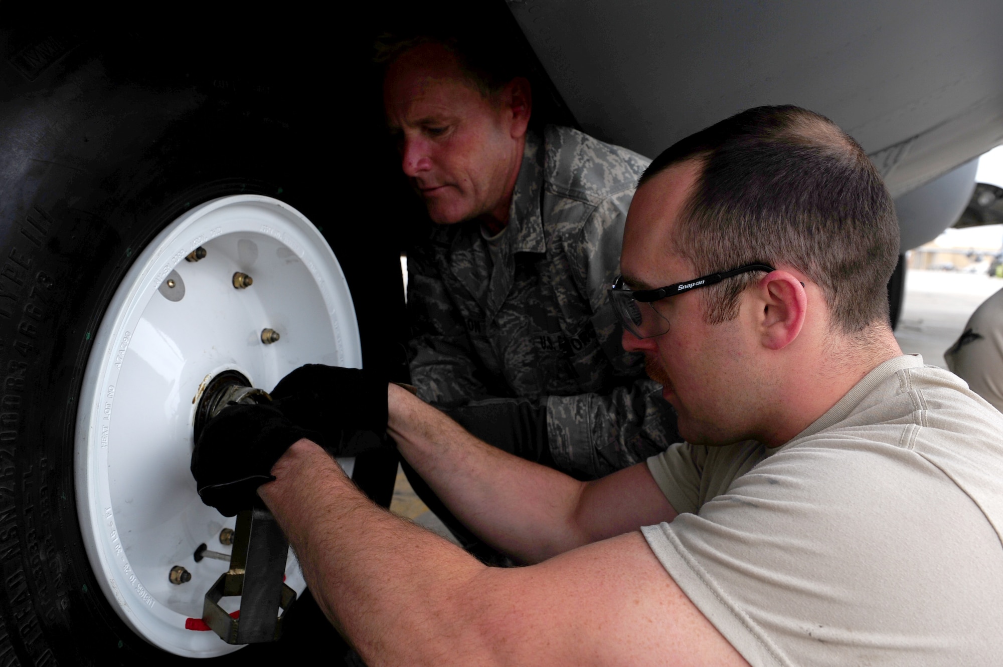 U.S. Air Force Staff Sgt. Justin Greenhow and Master Sgt. Jeff Dillon, 455th Expeditionary Aircraft Maintenance Squadron crew chiefs, secure a new tire to the nose landing gear of a C-130 Hercules aircraft during a tire change procedure at Bagram Airfield, Afghanistan, April 9, 2011. Greenhow and Dillon are deployed from the Delaware Air National Guard’s 166th Aircraft Maintenance Squadron, New Castle, Del., supporting Operation Enduring Freedom. (U.S. Air Force photo/Master Sgt. William Greer)