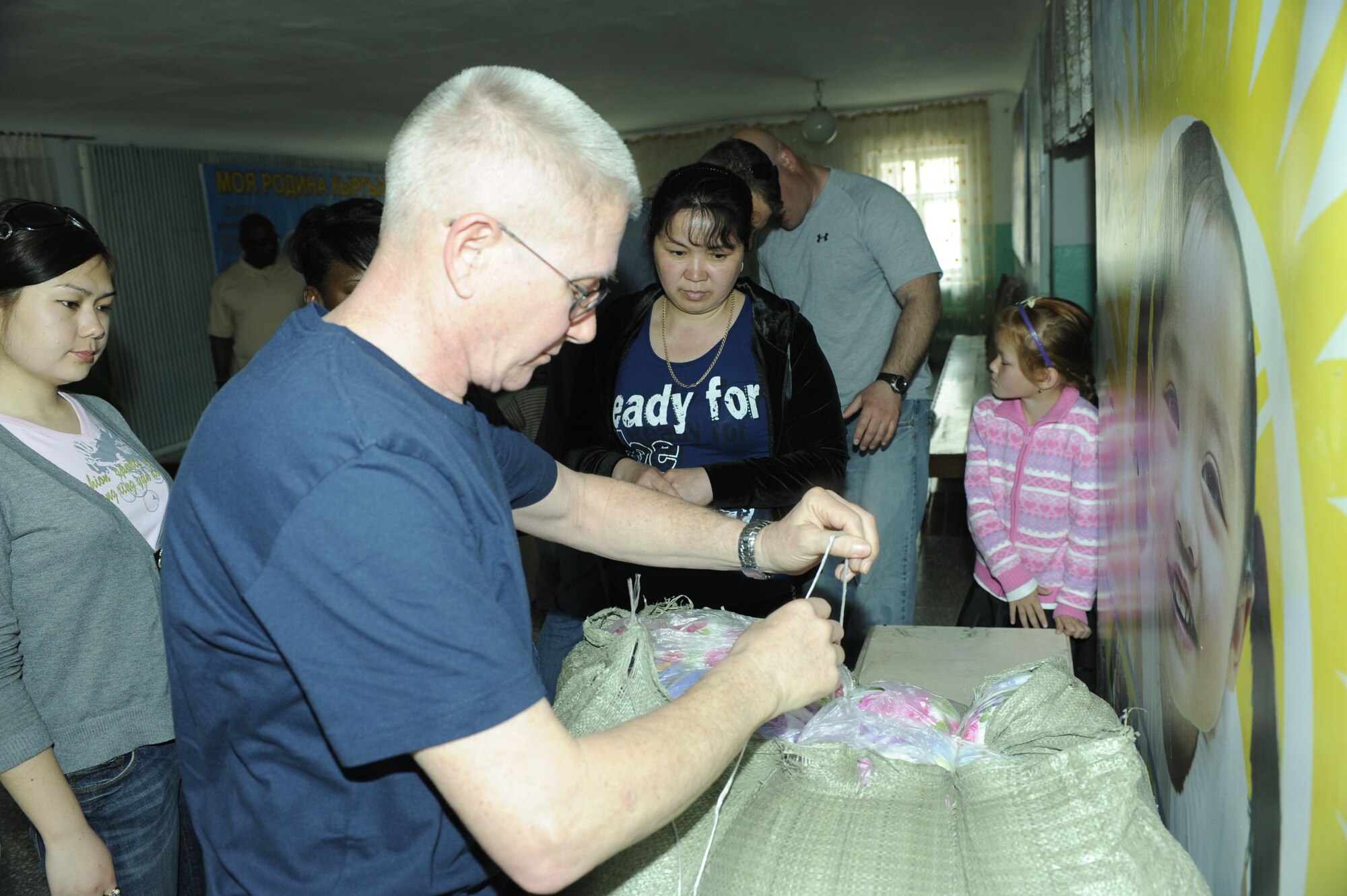 NIZNE-CHUISK VILLAGE, Kyrgyzstan - Master Sgt. Michael Dinneen, 376th Air Expeditionary Wing chapel, unloads donated blankets at the village orphanage here Monday.  Manas Area Benefit Outreach Society reps visited the village to donate items and their time for games and laughter with the local youth.  (U.S. Air Force photo/Tech. Sgt. Jerome C. Baysmore) 
