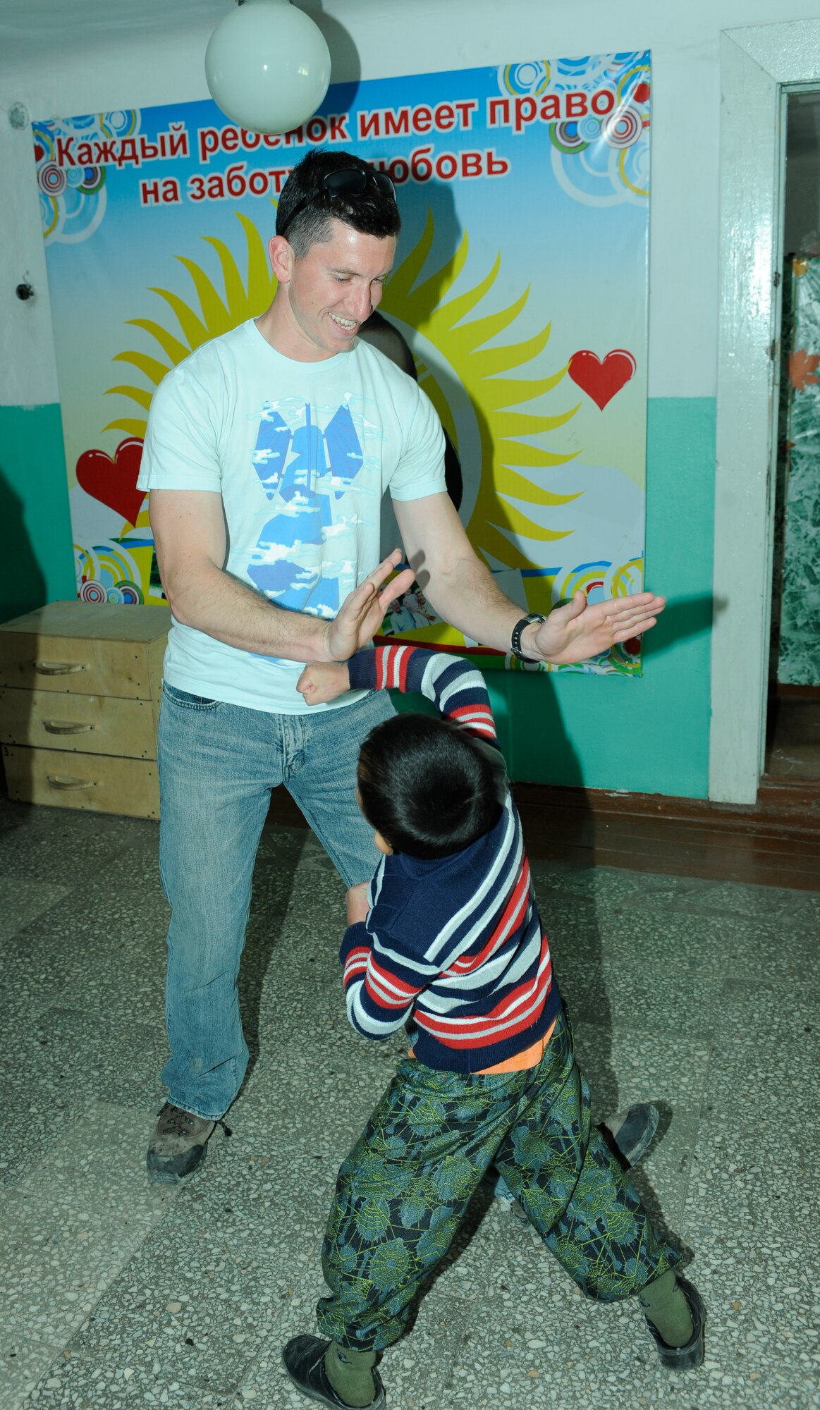 NIZNE-CHUISK VILLAGE, Kyrgyzstan -Staff Sgt. Jedd Lucas, 376th Expeditionary Civil Engineer Squadron Explosive Ordnance Disposal technician, shares a moment with one of the children at the village orphanage here Monday.  Manas Area Benefit Outreach Society reps visited the village to donate items and their time for games and laughter with the local youth.  (U.S. Air Force photo/Tech. Sgt. Jerome C. Baysmore) 

