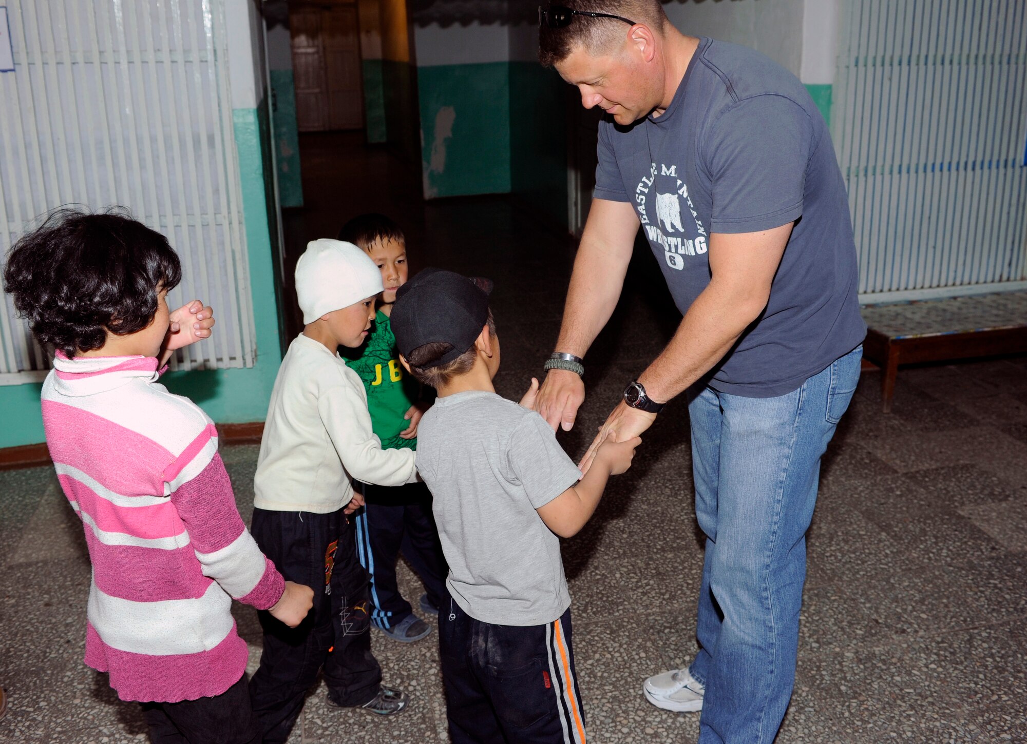 NIZNE-CHUISK VILLAGE, Kyrgyzstan -Staff Sgt. Guy Smith, 376th Expeditionary Civil Engineer Squadron Explosive Ordnance Disposal technician, greets children at the village orphanage here Monday.  Manas Area Benefit Outreach Society reps visited the village to donate items and their time for games and laughter with the local youth.  (U.S. Air Force photo/Tech. Sgt. Jerome C. Baysmore) 
