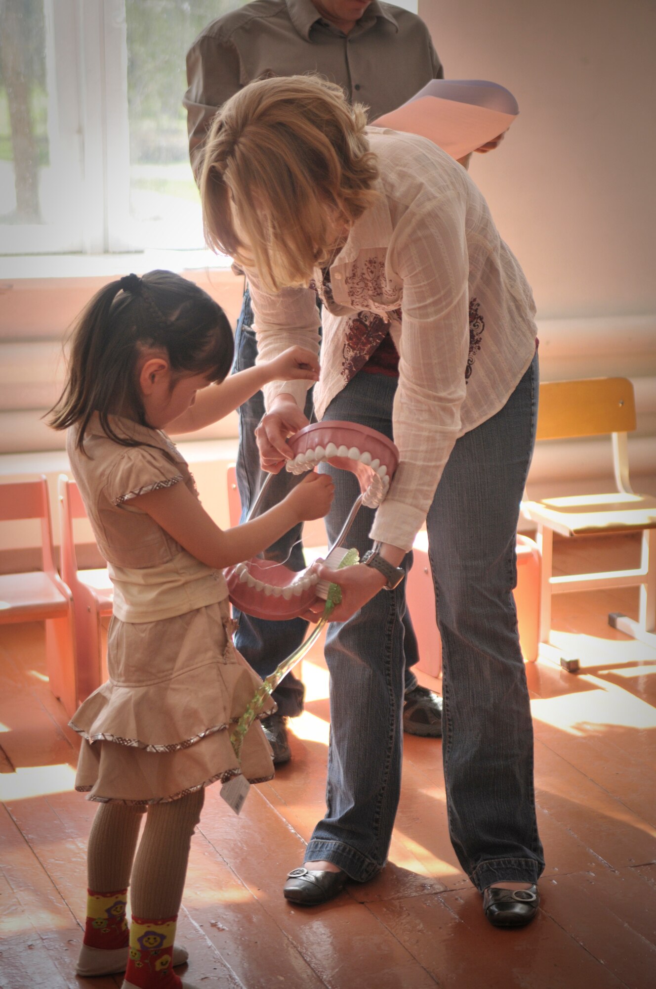 TRANSIT CENTER AT MANAS, Kyrgyzstan  - Members from the Transit Center at Manas meet with children from the Vasilievka school in Vasilievka village  as a part of a Dental outreach mission April 12.  Dental personnel demonstrated the correct way to brush and floss, what kinds of foods are good or bad for teeth and even played a few fun games designed to teach them about teeth. They also donated 90 kits with floss, toothpaste, and tooth brushes, the Civil Air Patrol also donated over 900 dollars and 50 pounds worth of toys and supplies to the school. (U.S. Air Force photo/Staff Sgt. Stacy Moless)


